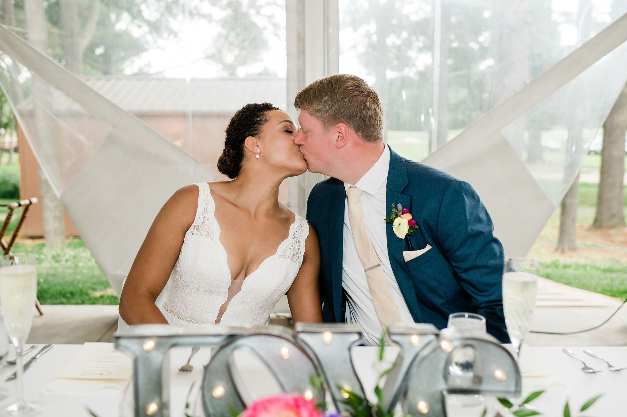 Bride and groom kissing at their sweetheart table