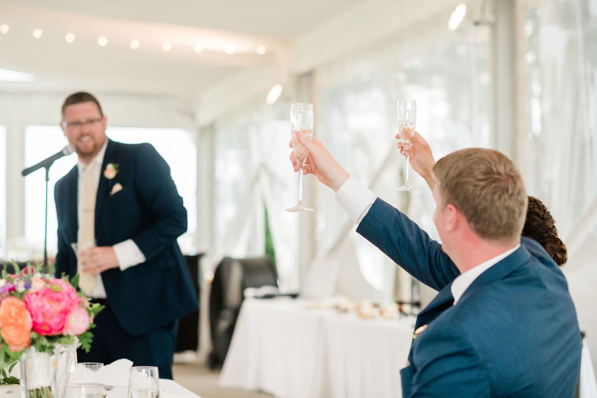 Bride and groom raise up their glasses for a toast