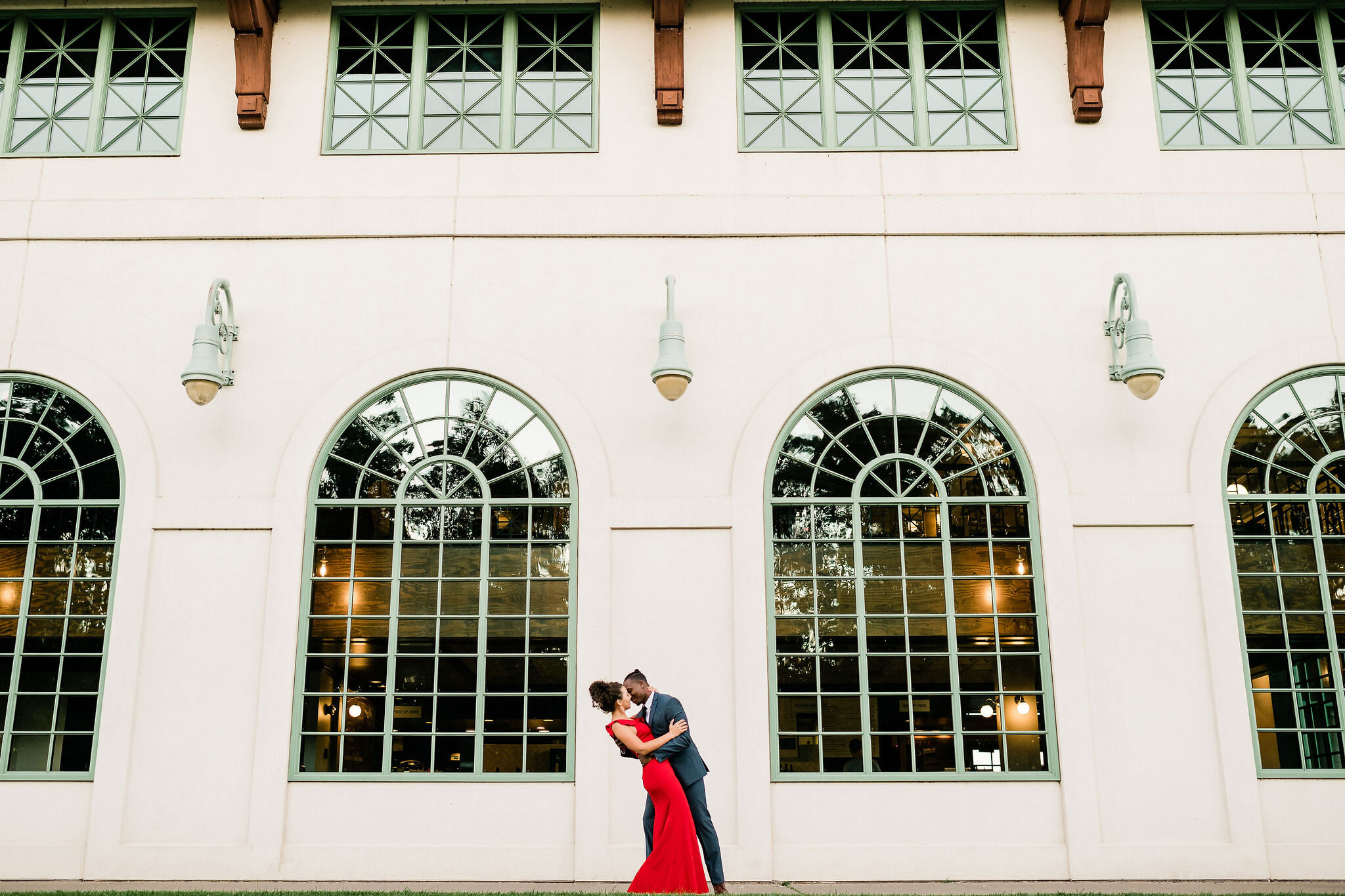 Engaged couple in front of a building with a lot of windows