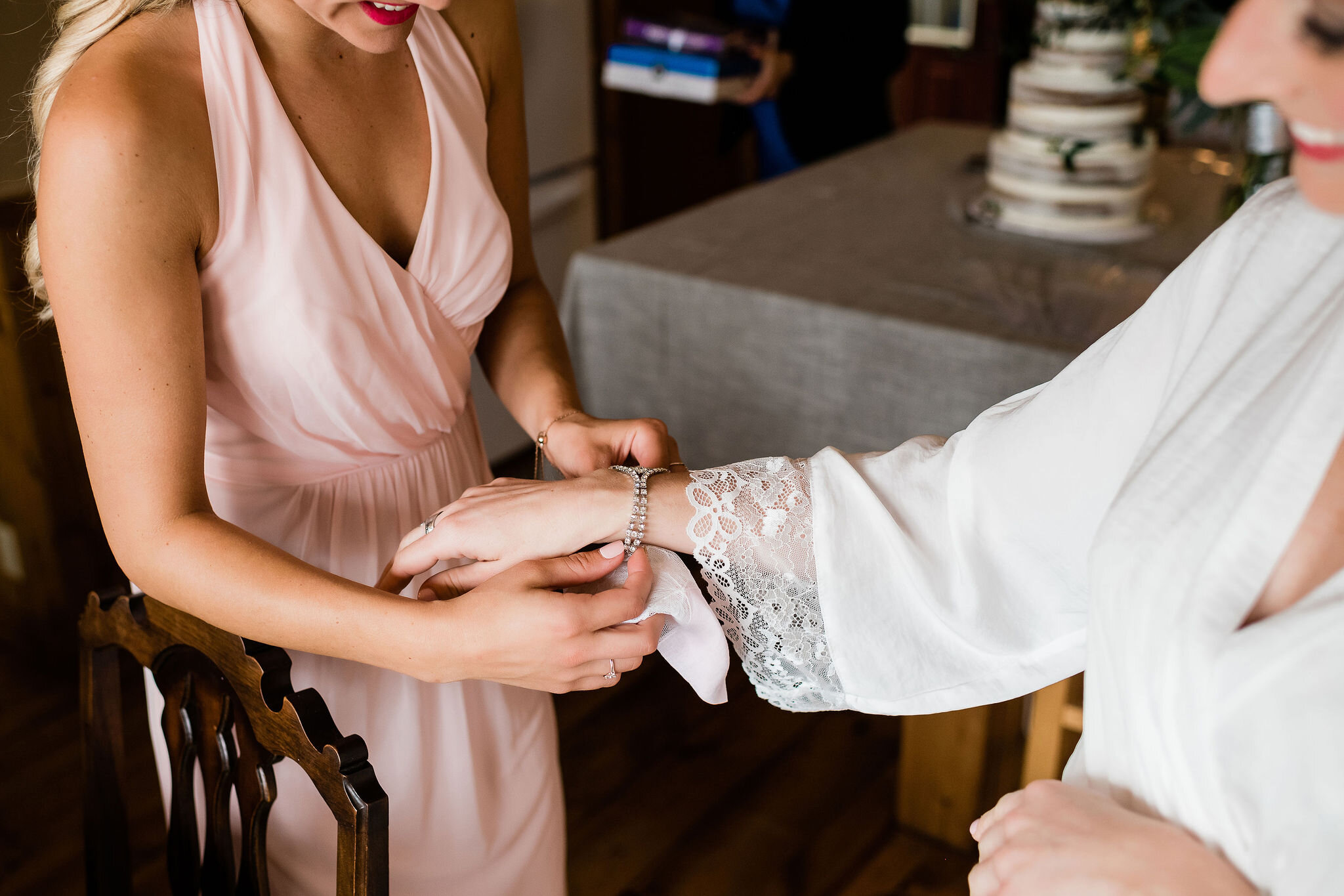 Maid of honor putting bride's bracelet on