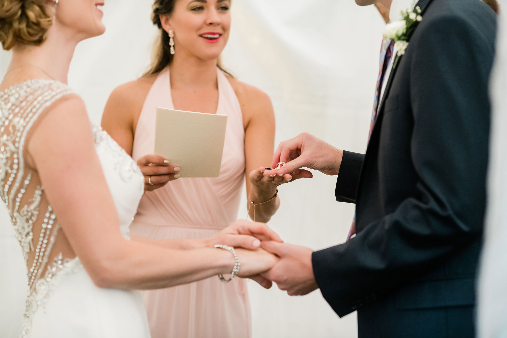 Officiant handing groom the wedding rings