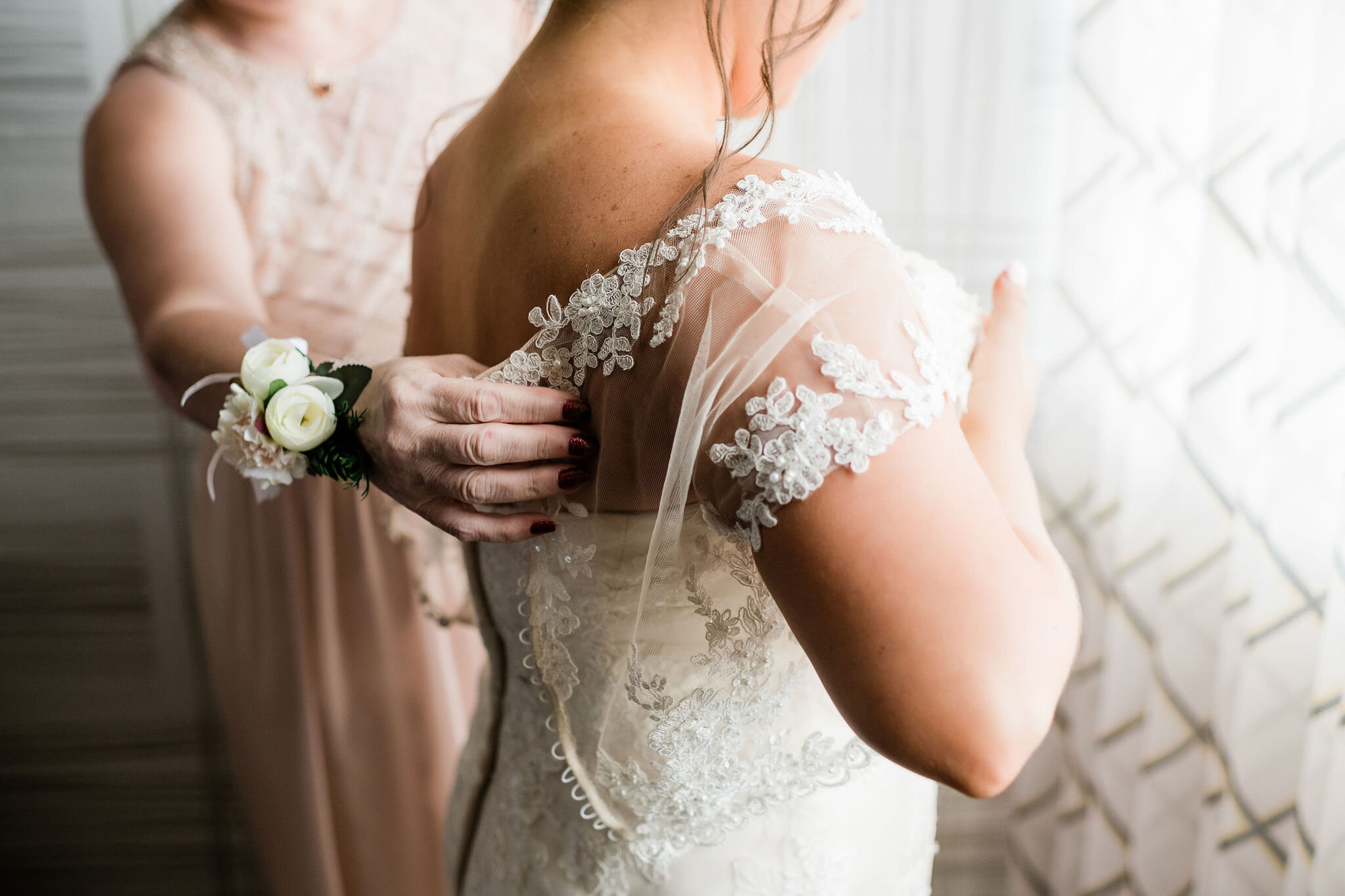 Bride's mom putting her lace overlay on