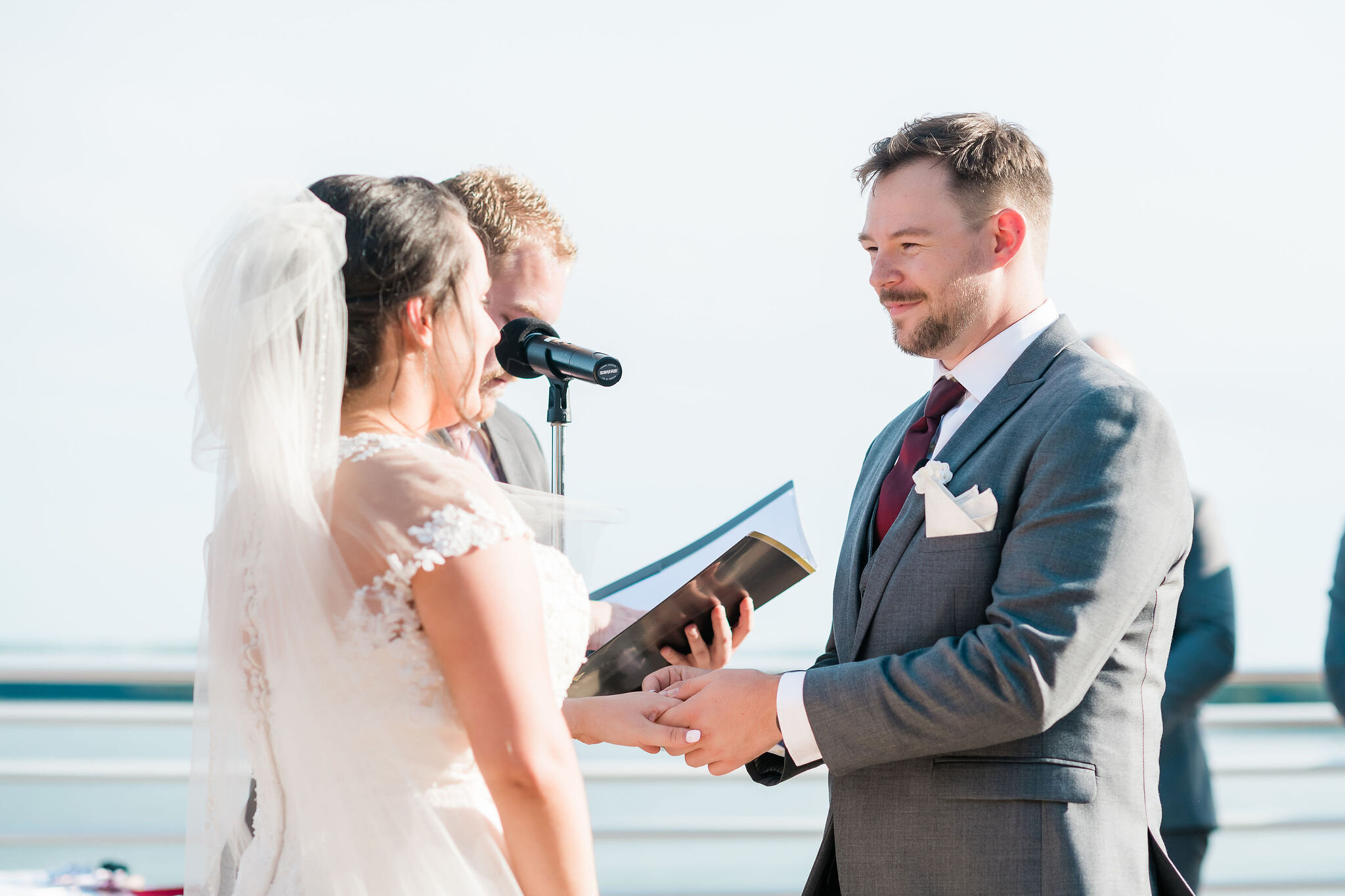 Groom putting ring on bride's finger