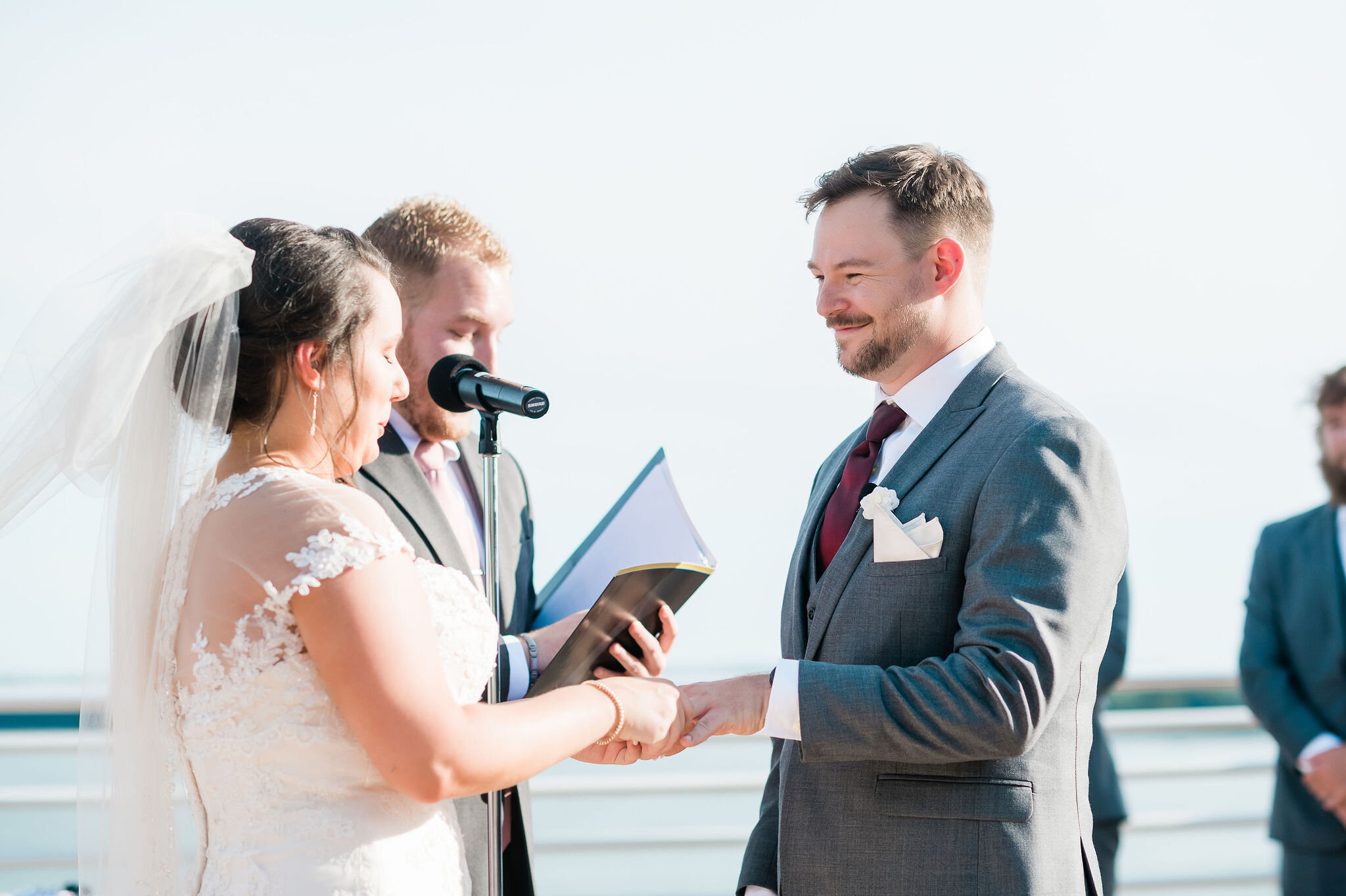 Bride putting ring on groom's finger