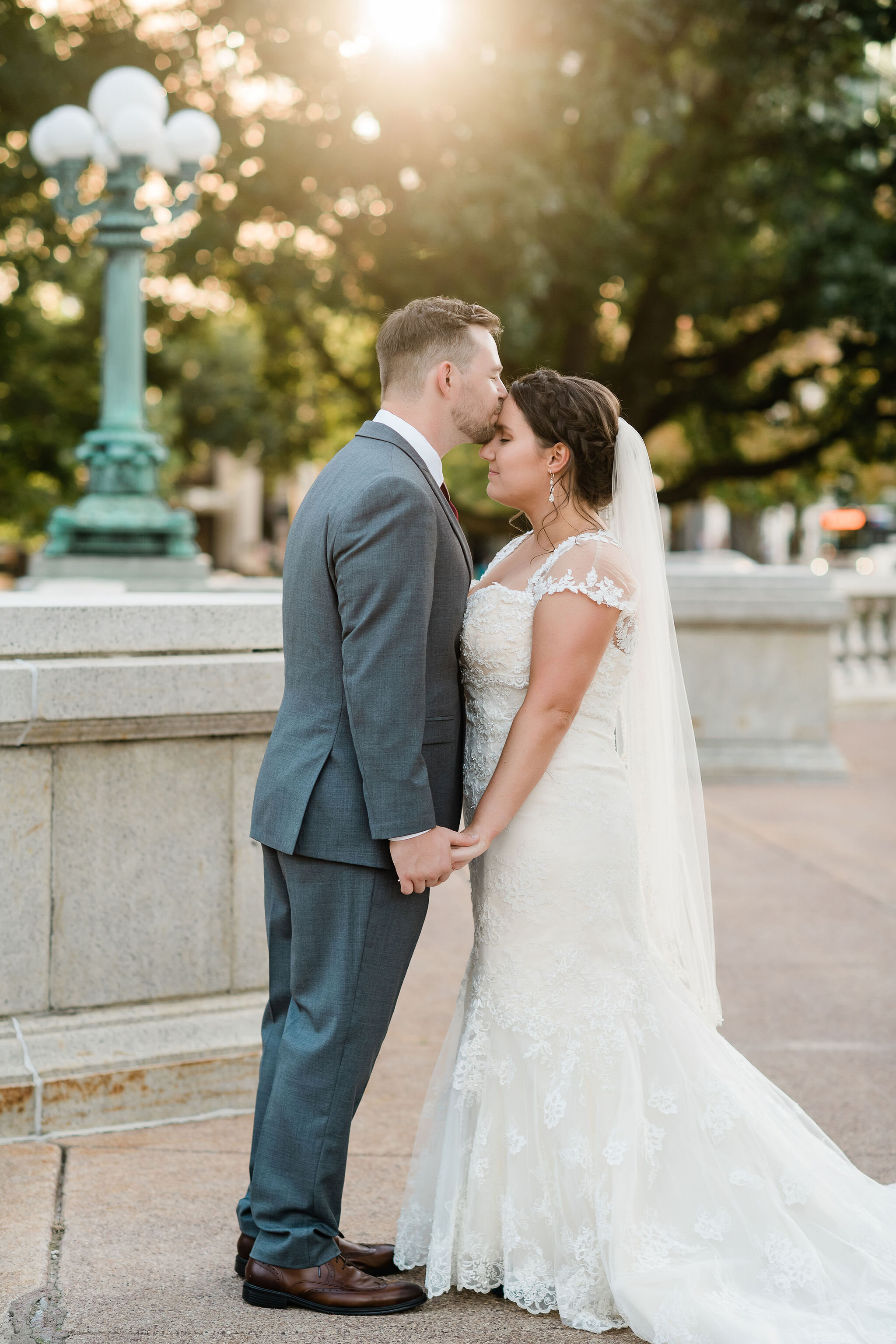 Groom kissing bride's forehead