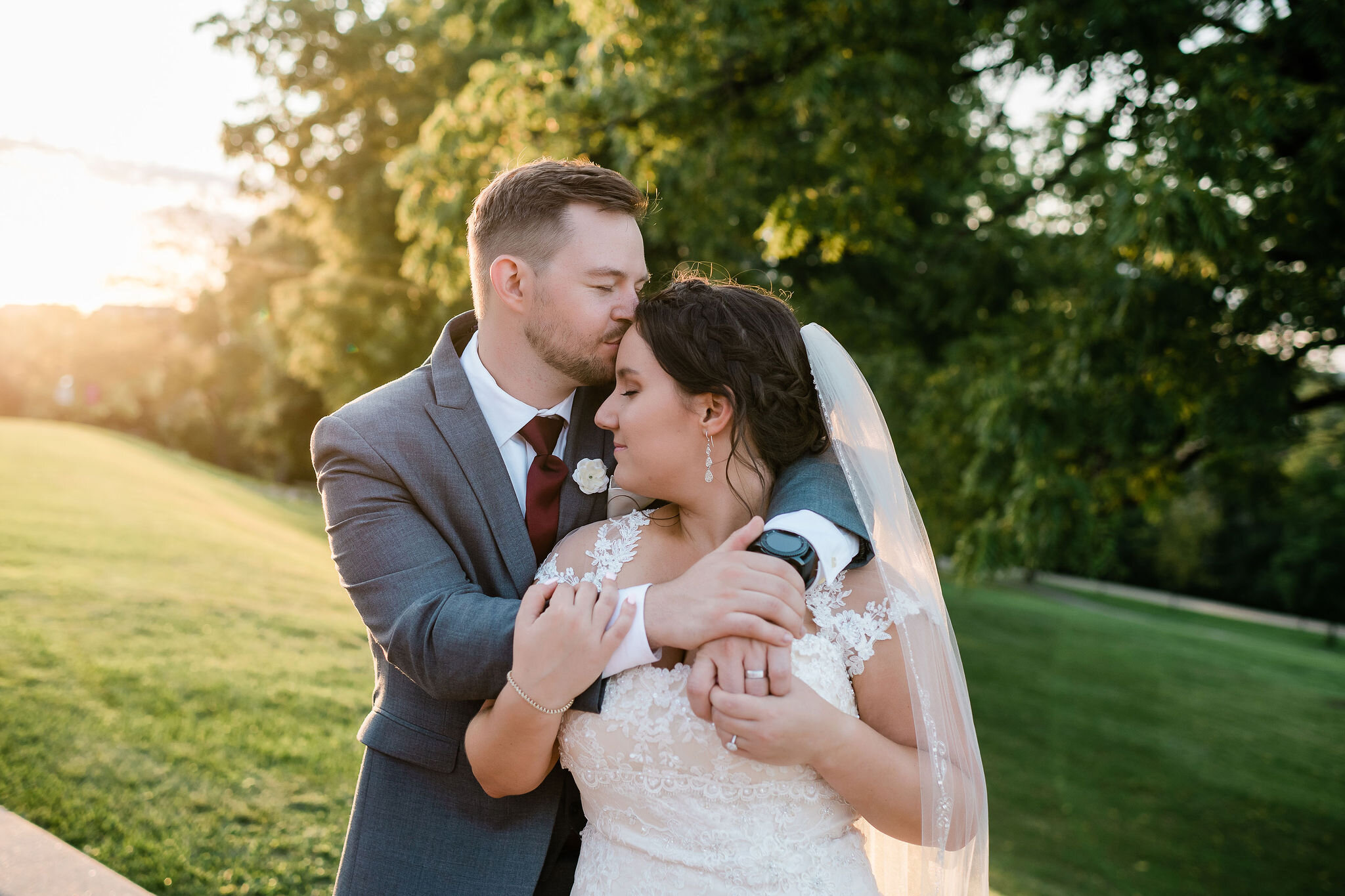 Groom kissing bride's forehead