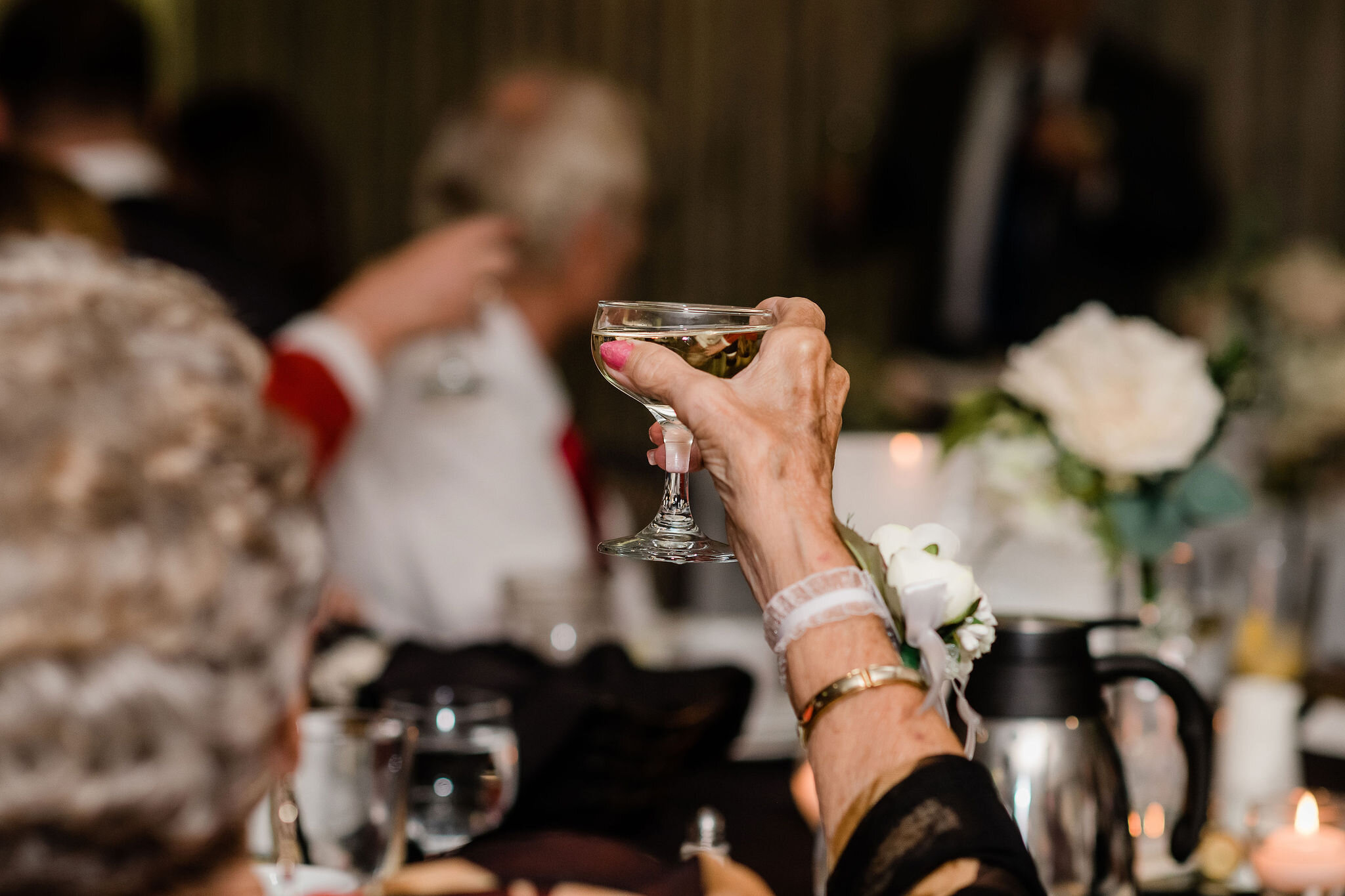 Wedding guest raising their glass for a toast