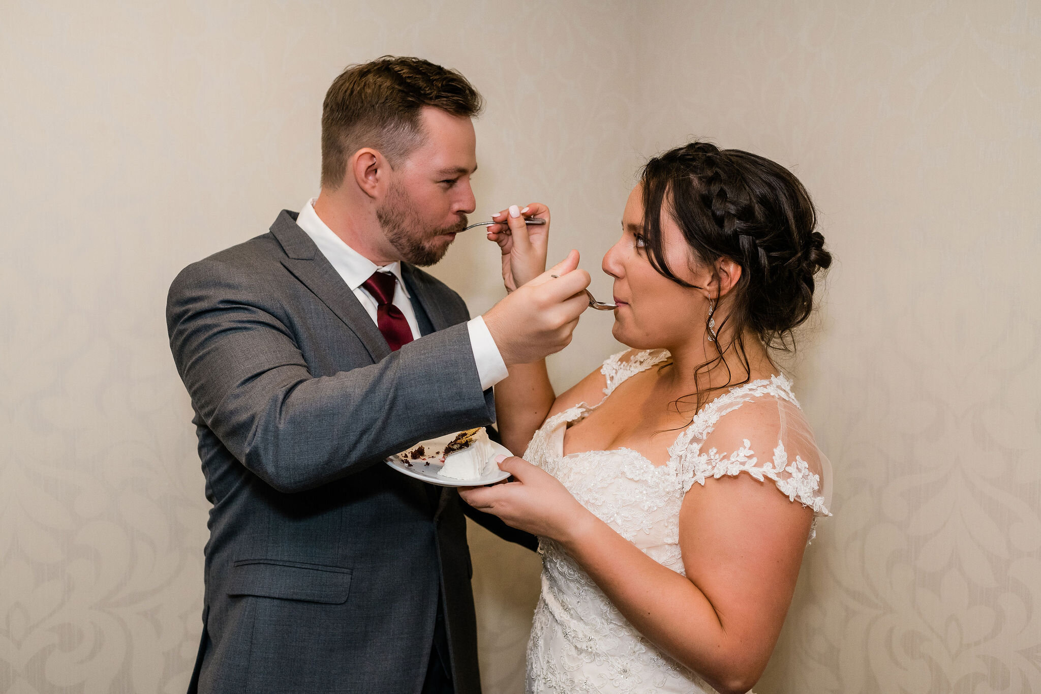 Bride and groom feeding each other cake