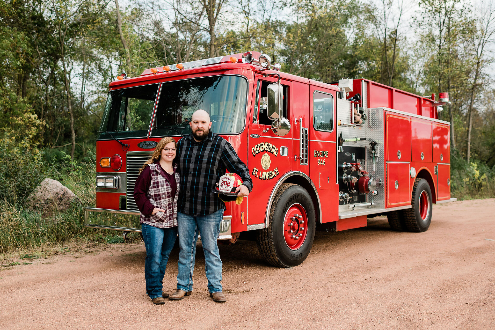 Engaged couple in front of a fire truck