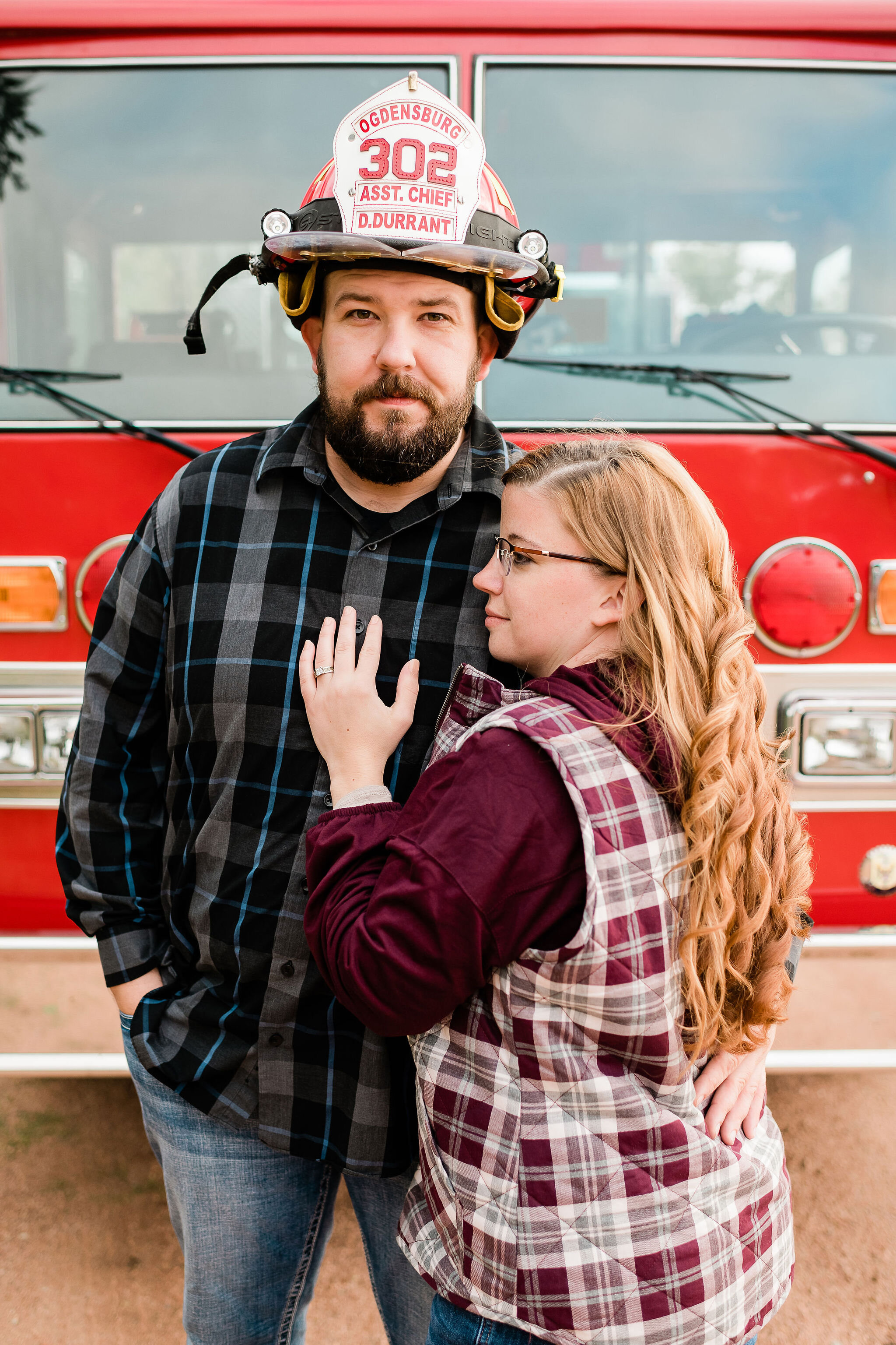 Engaged couple in front of a fire truck