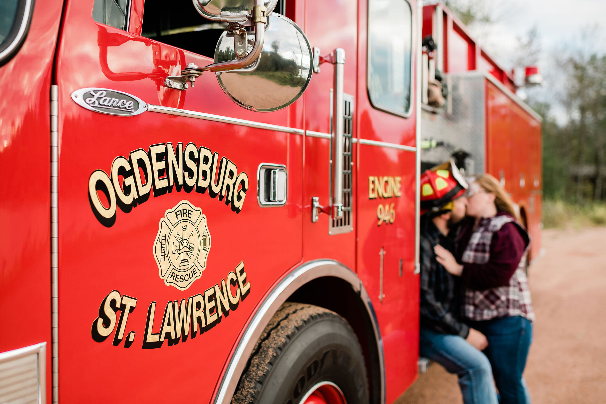 Fire truck logo with engaged couple kissing in the background