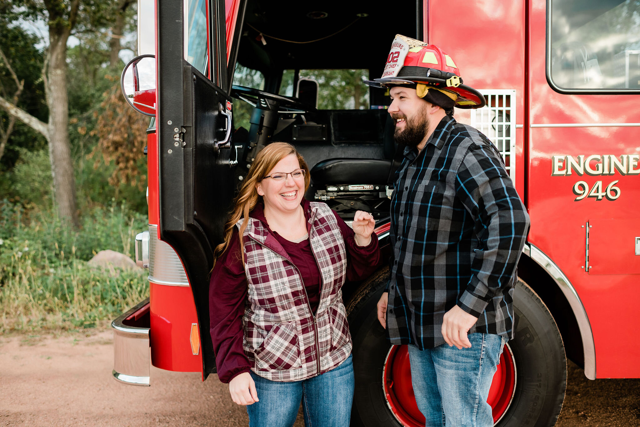 Engaged couple in front of a fire truck
