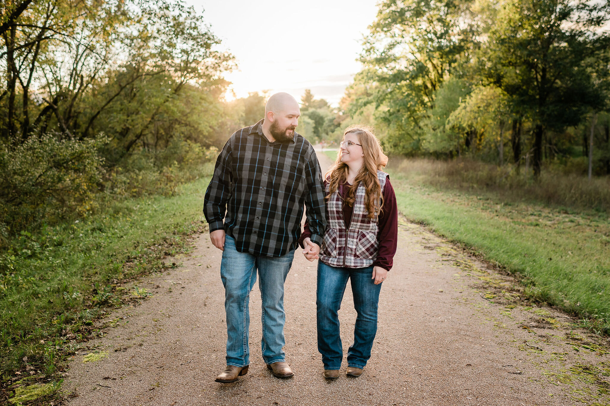 Engaged couple walking down a path