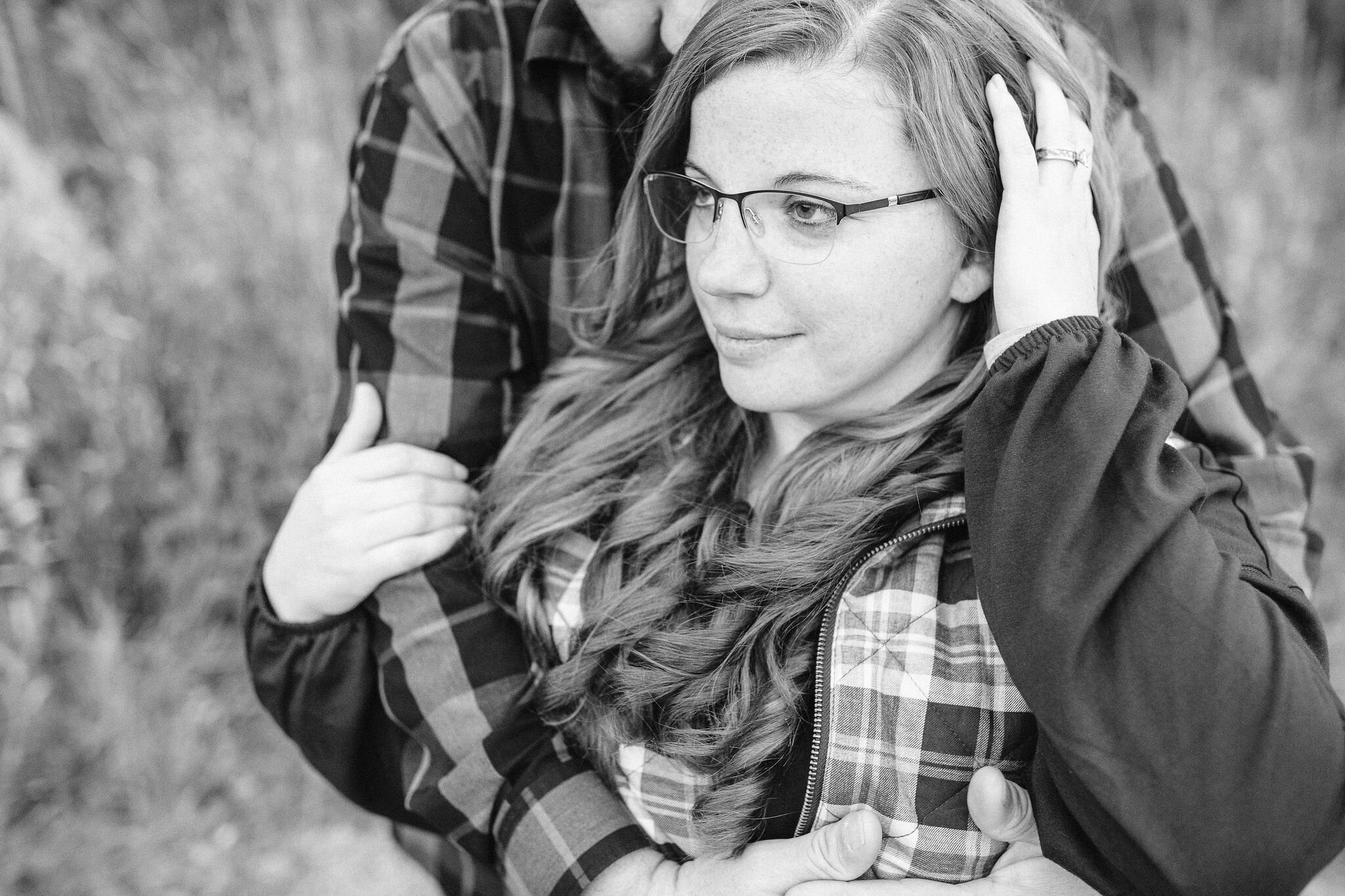 Woman brushes her hair back showing off her engagement ring