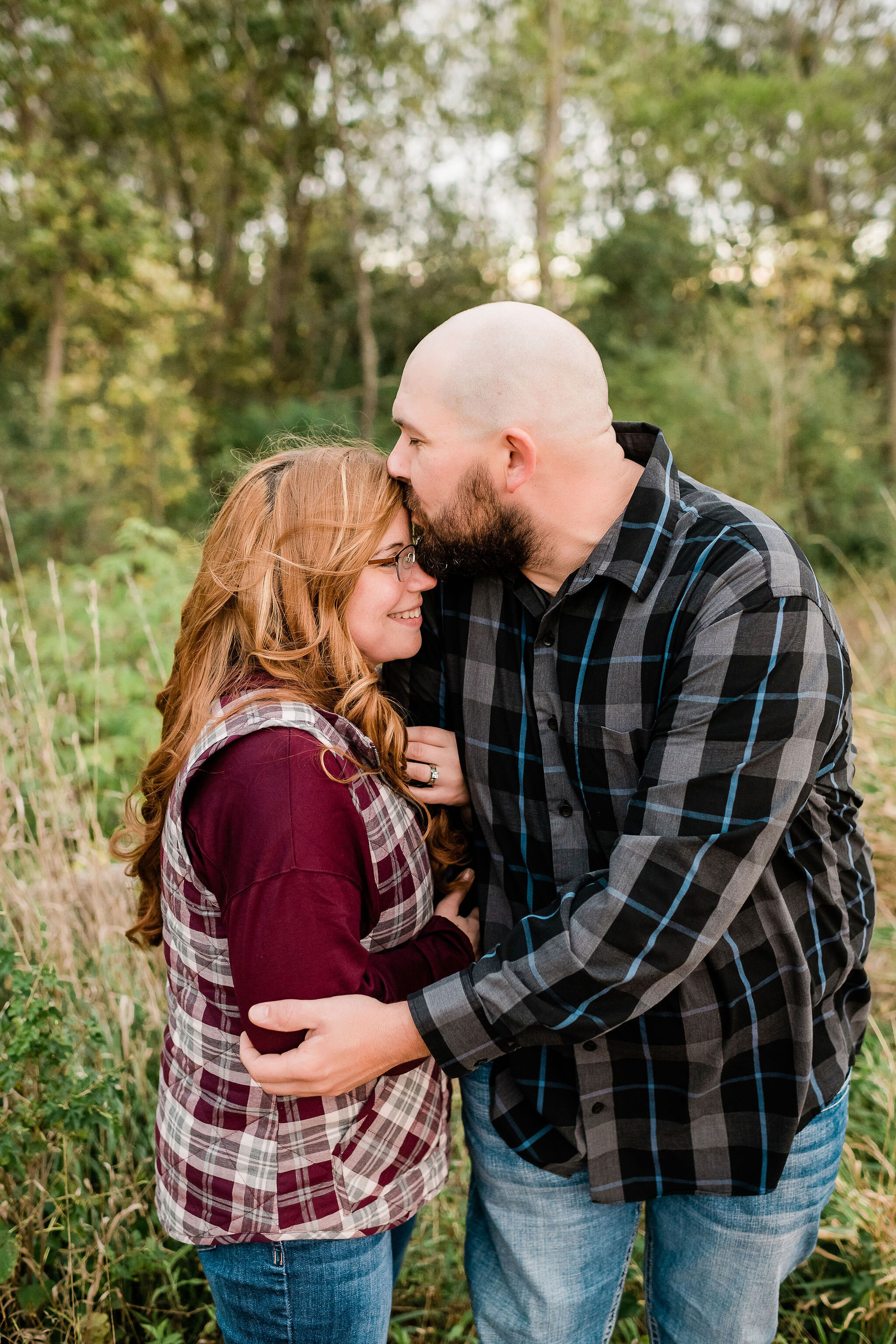 Man kissing his fiancé's forehead