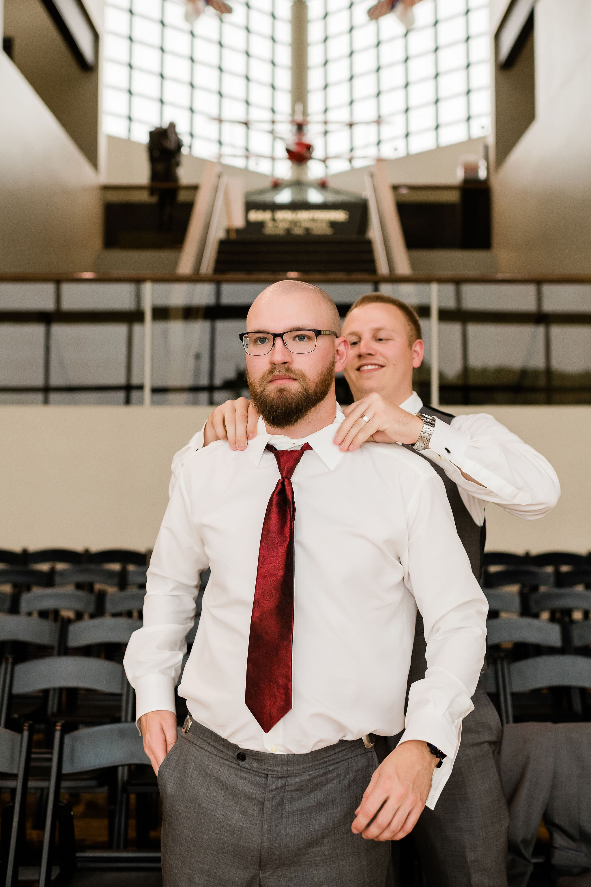 Groomsman helping groom with his tie