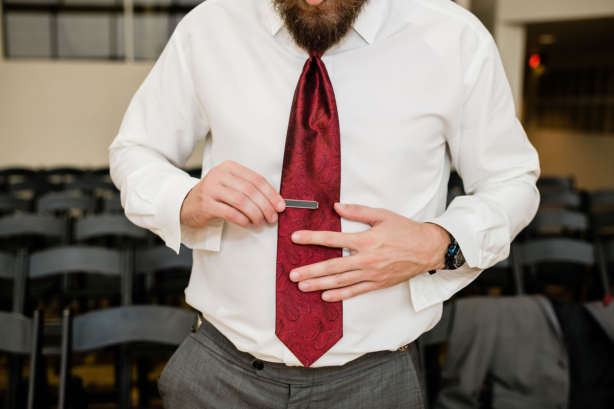Groom putting on his tie clip