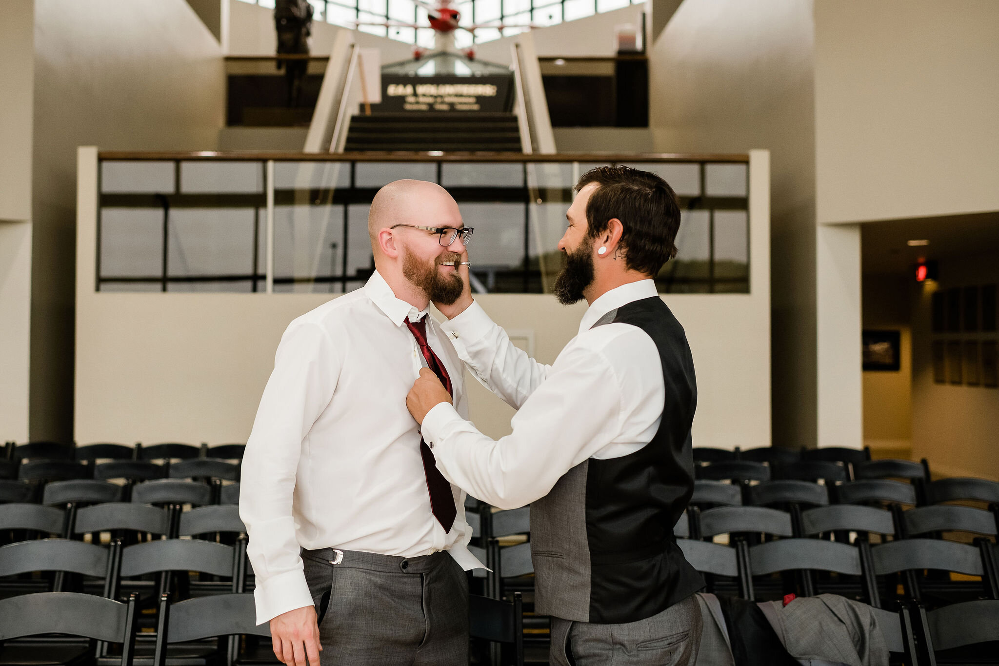 Groomsman helping groom with his tie