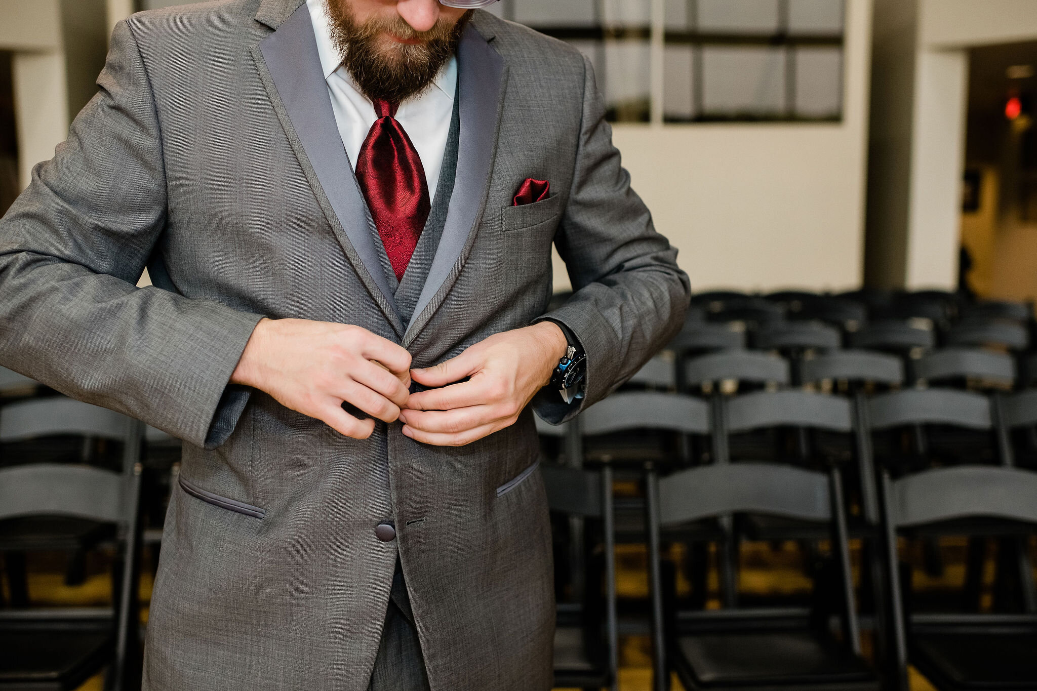 Groom buttoning up his jacket