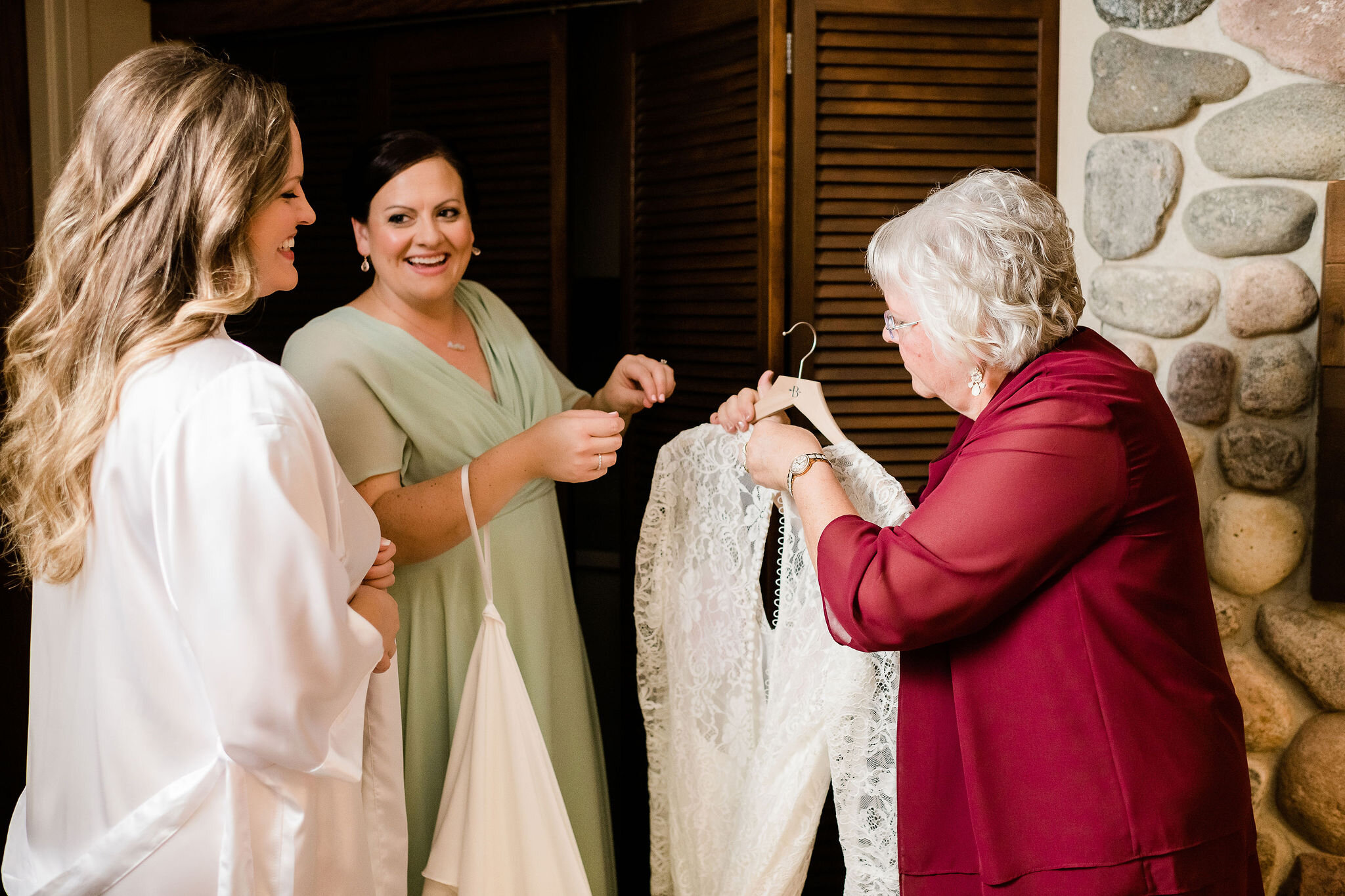 Bride and her mom getting ready to put her dress on