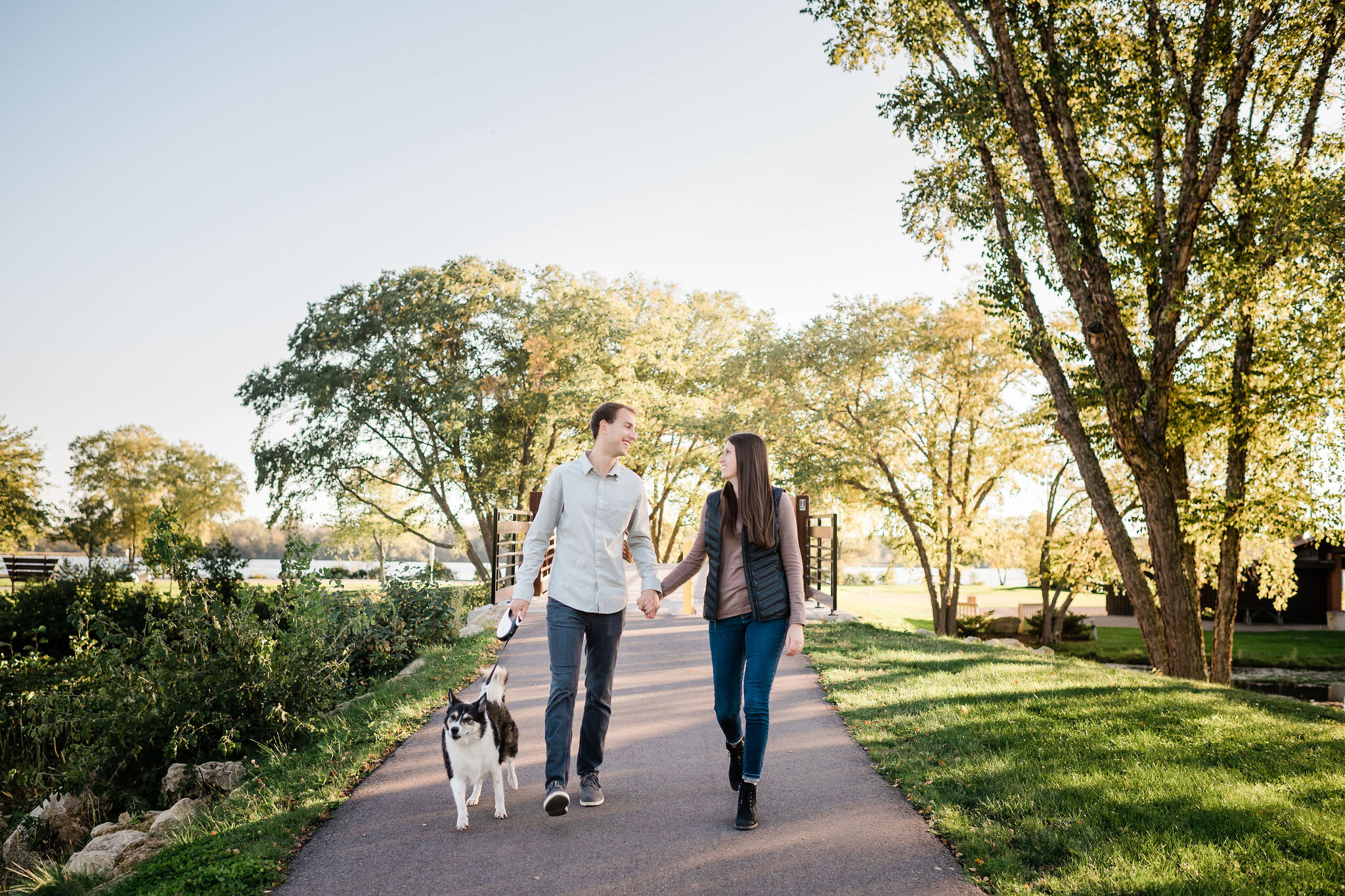 Engaged couple walking with their dog