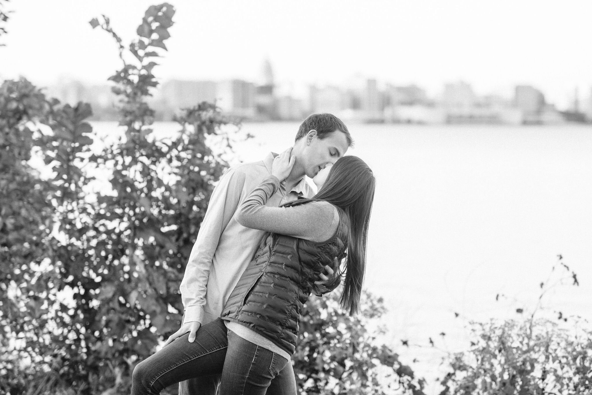 Man dipping his fiancé back and kissing her