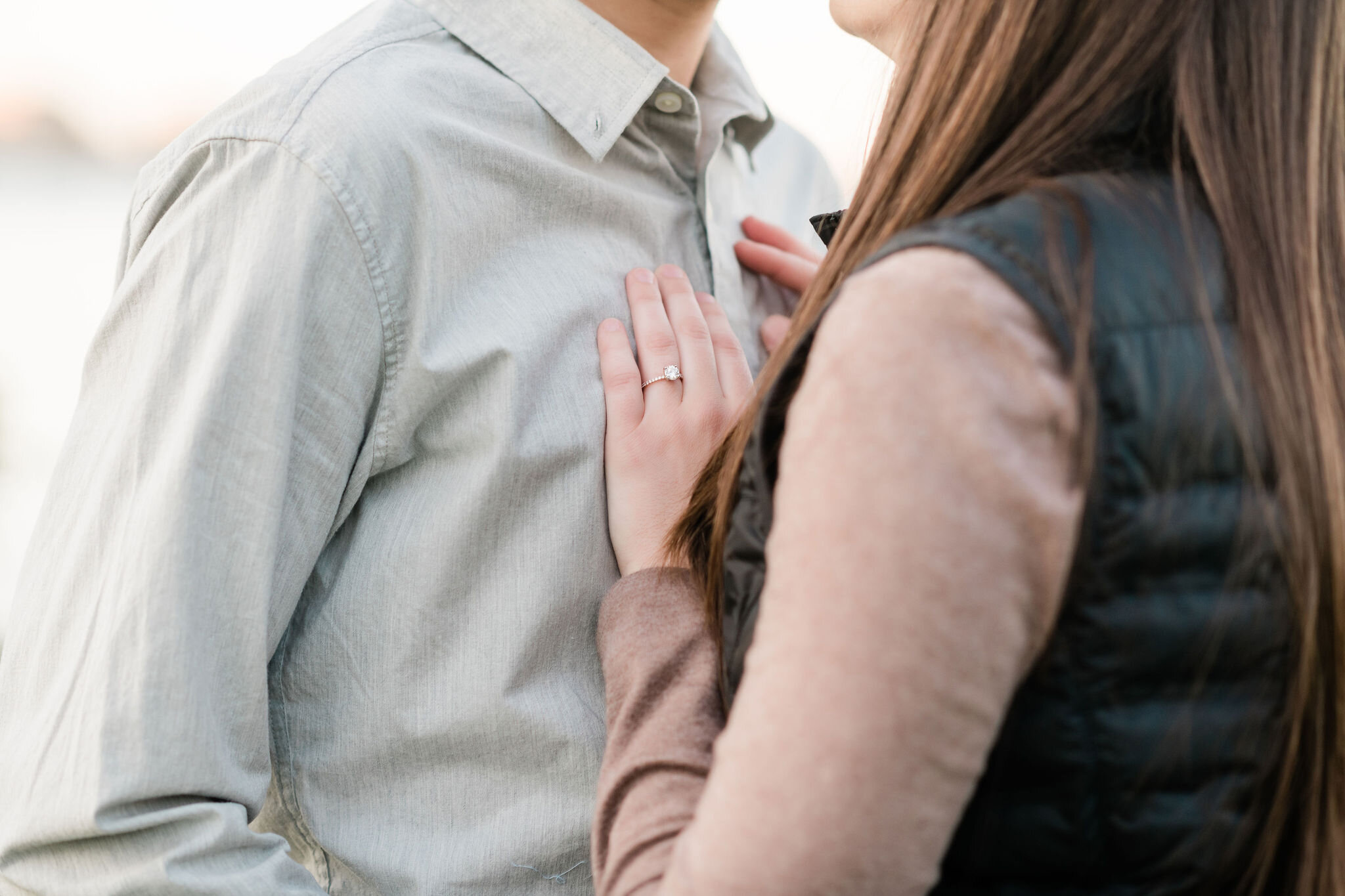 Woman resting her hand on her fiancé's chest