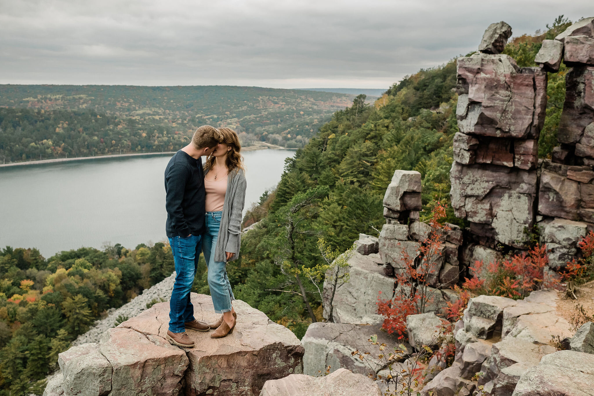 Engaged couple kissing on a rock