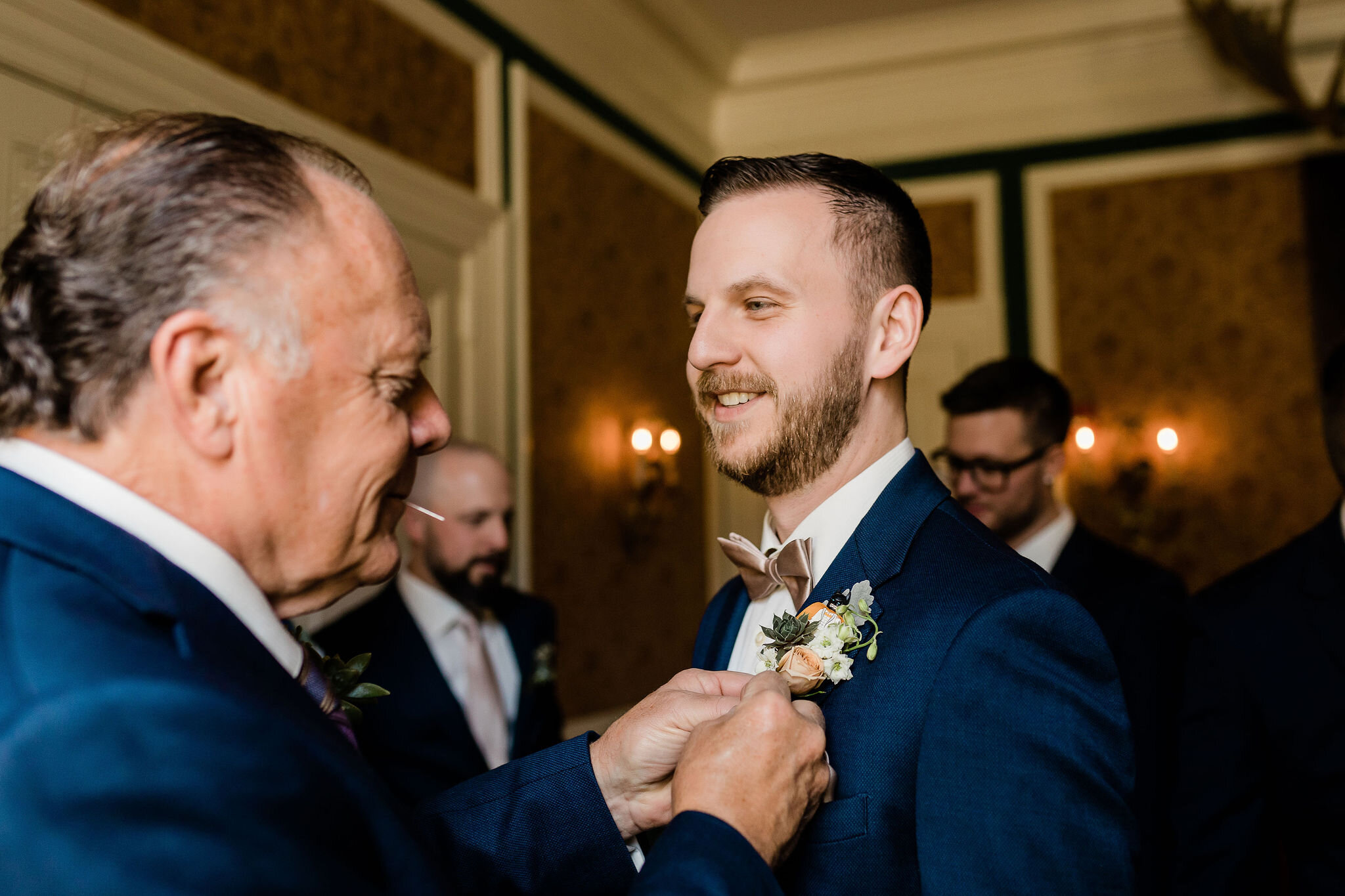 Groom's dad pinning on groom's boutonniere