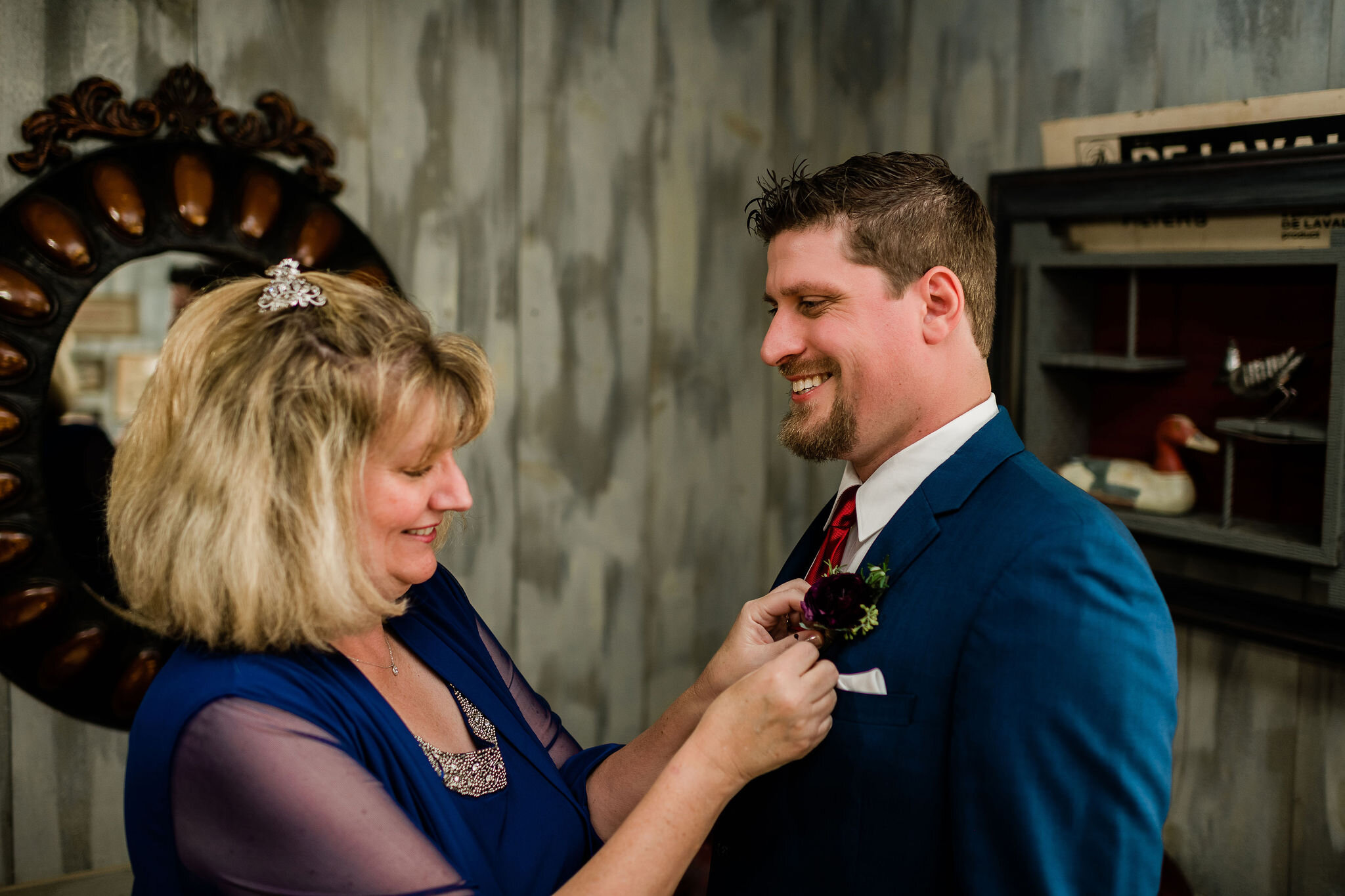 Groom's mom pinning his boutonniere on him