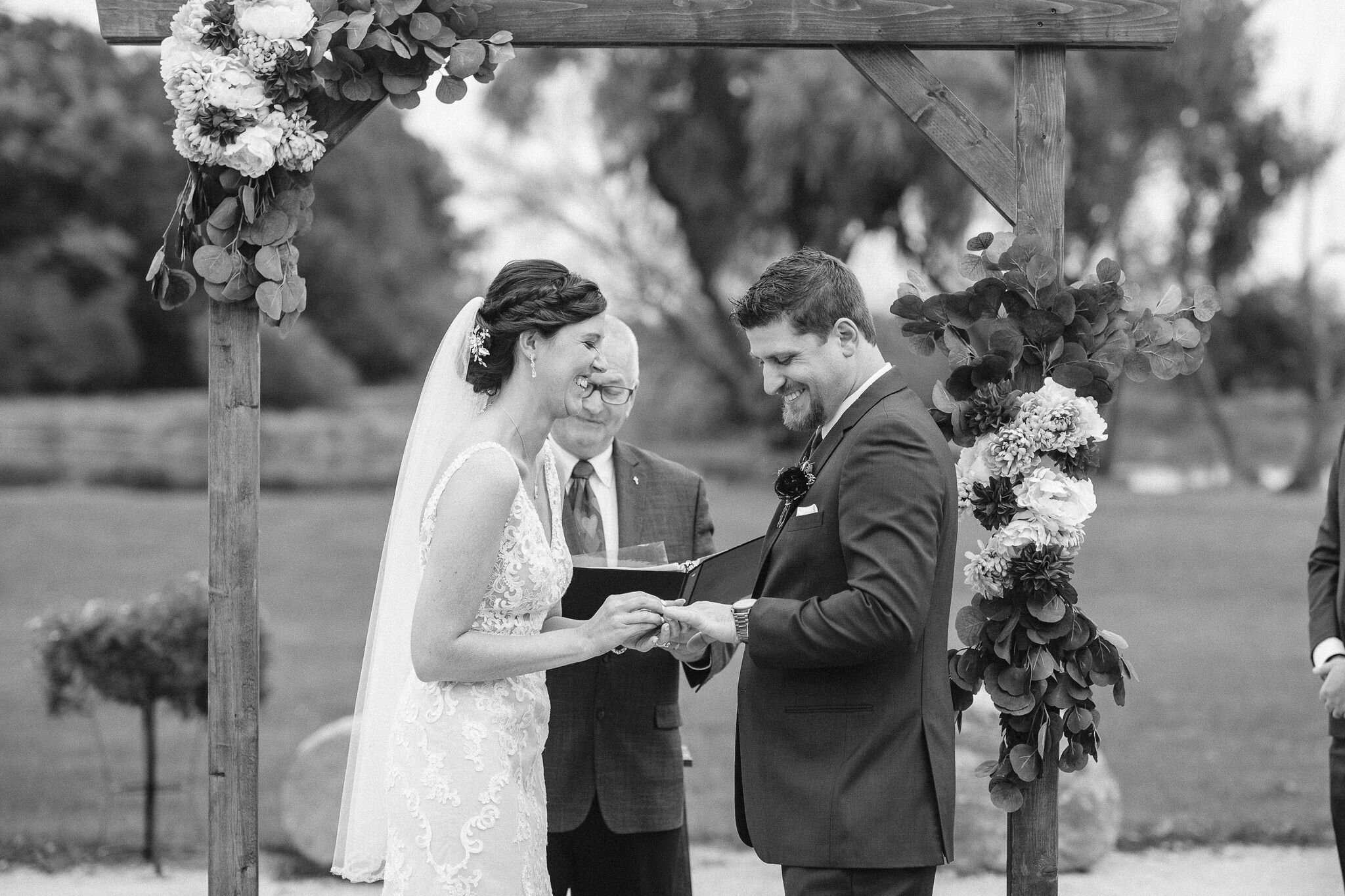 Bride putting ring on groom's finger