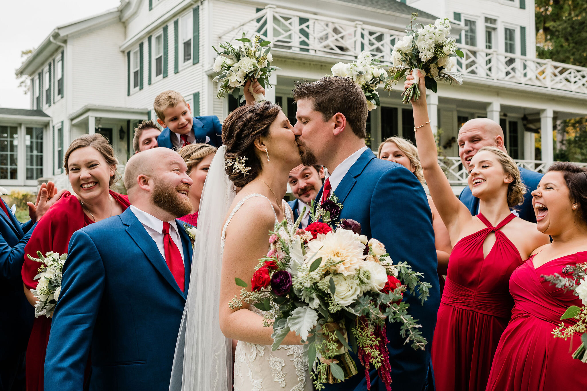 Bride and groom kissing while wedding party cheers