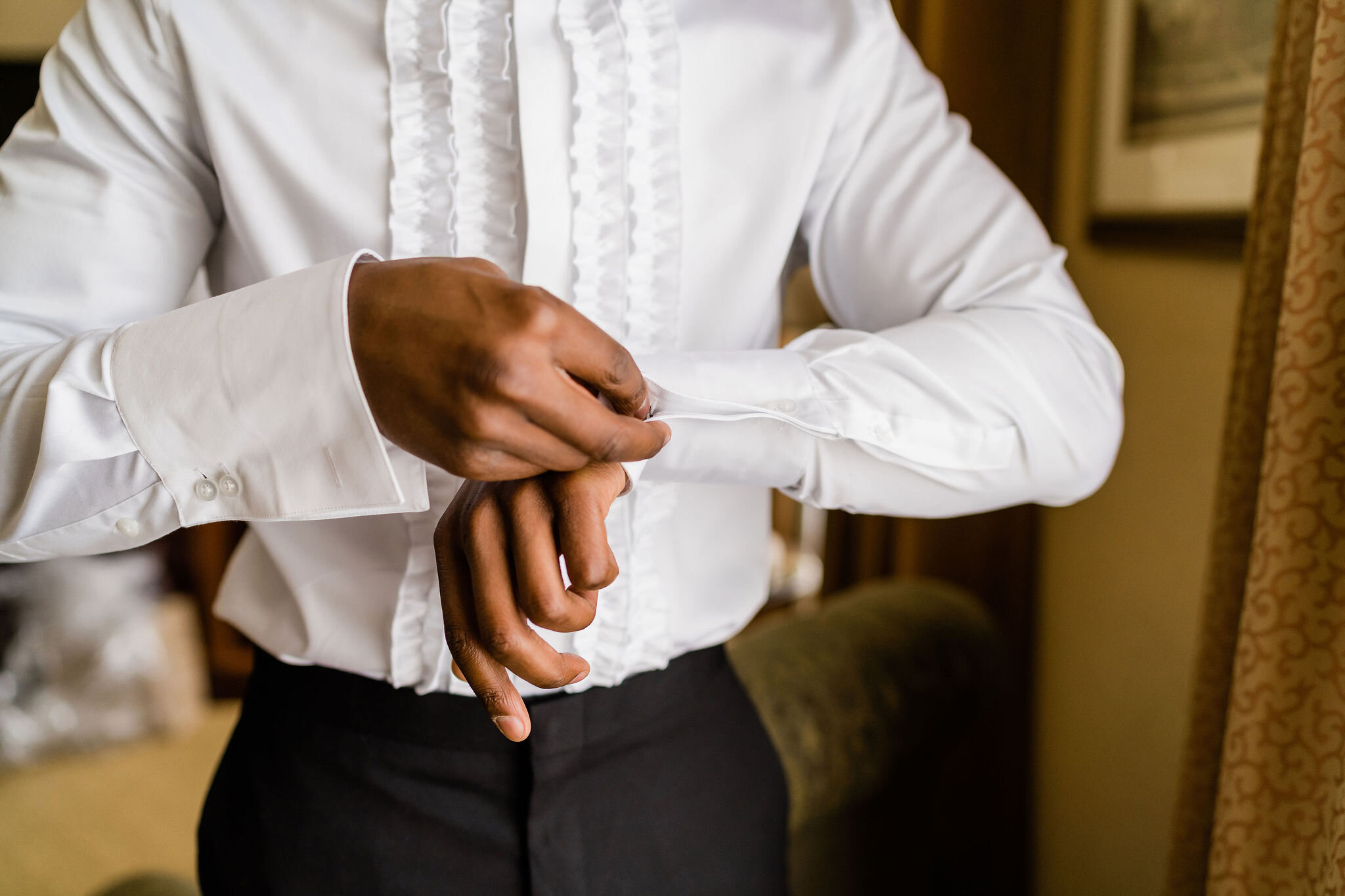 Groom putting his cufflinks in