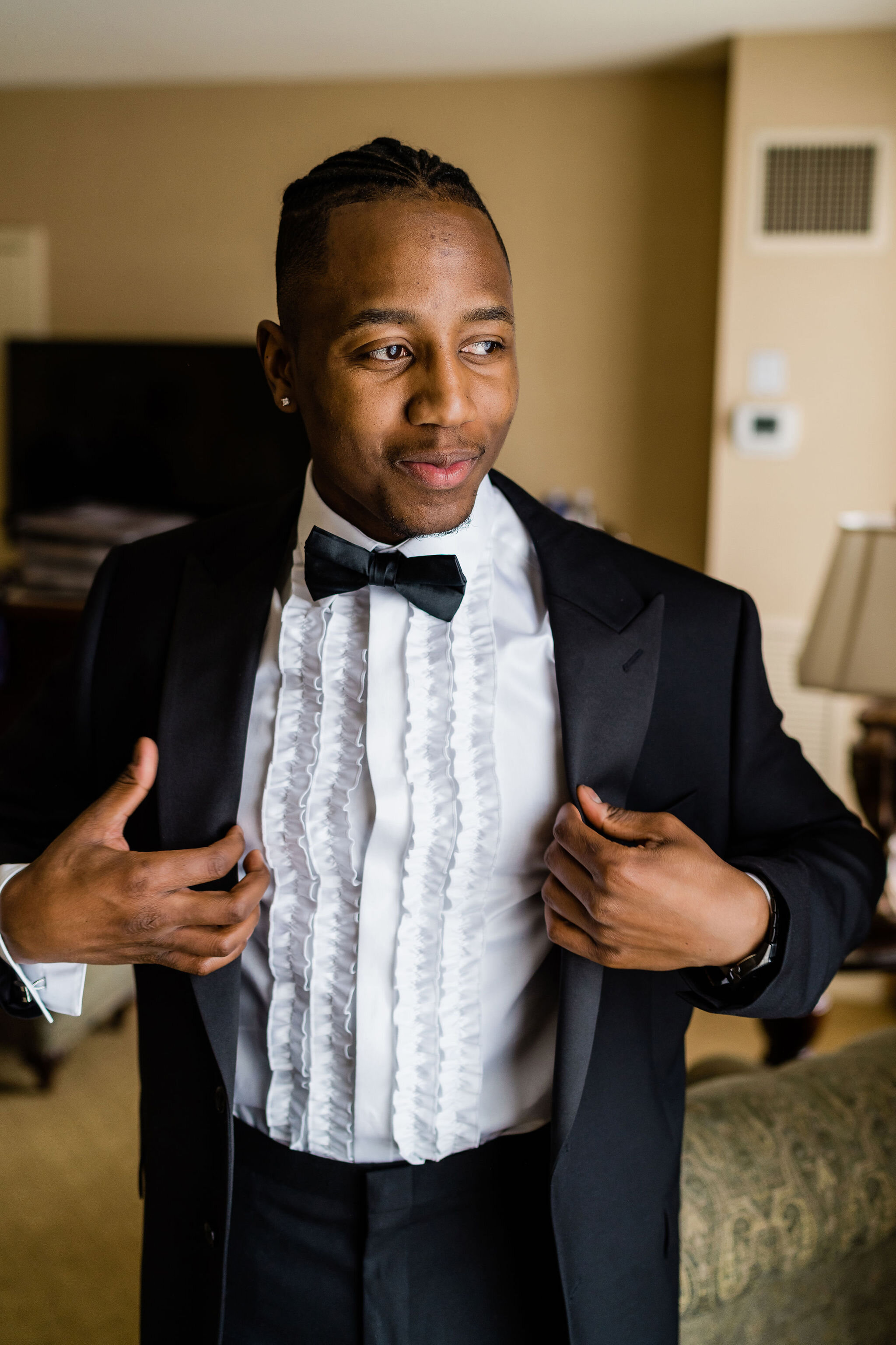 Groom putting his suit jacket on