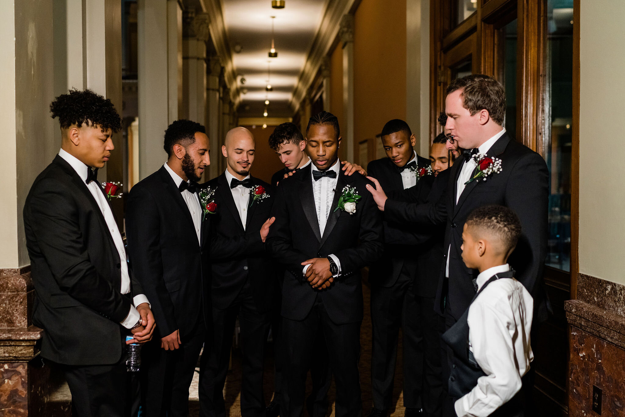 Groomsmen praying over groom