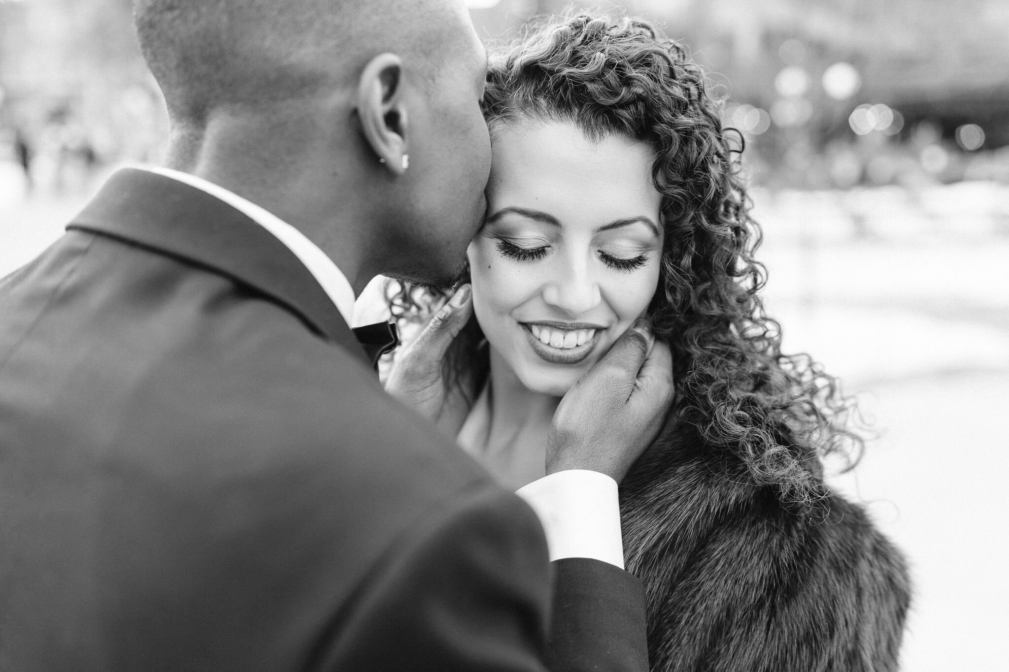 Groom kissing bride on her forehead