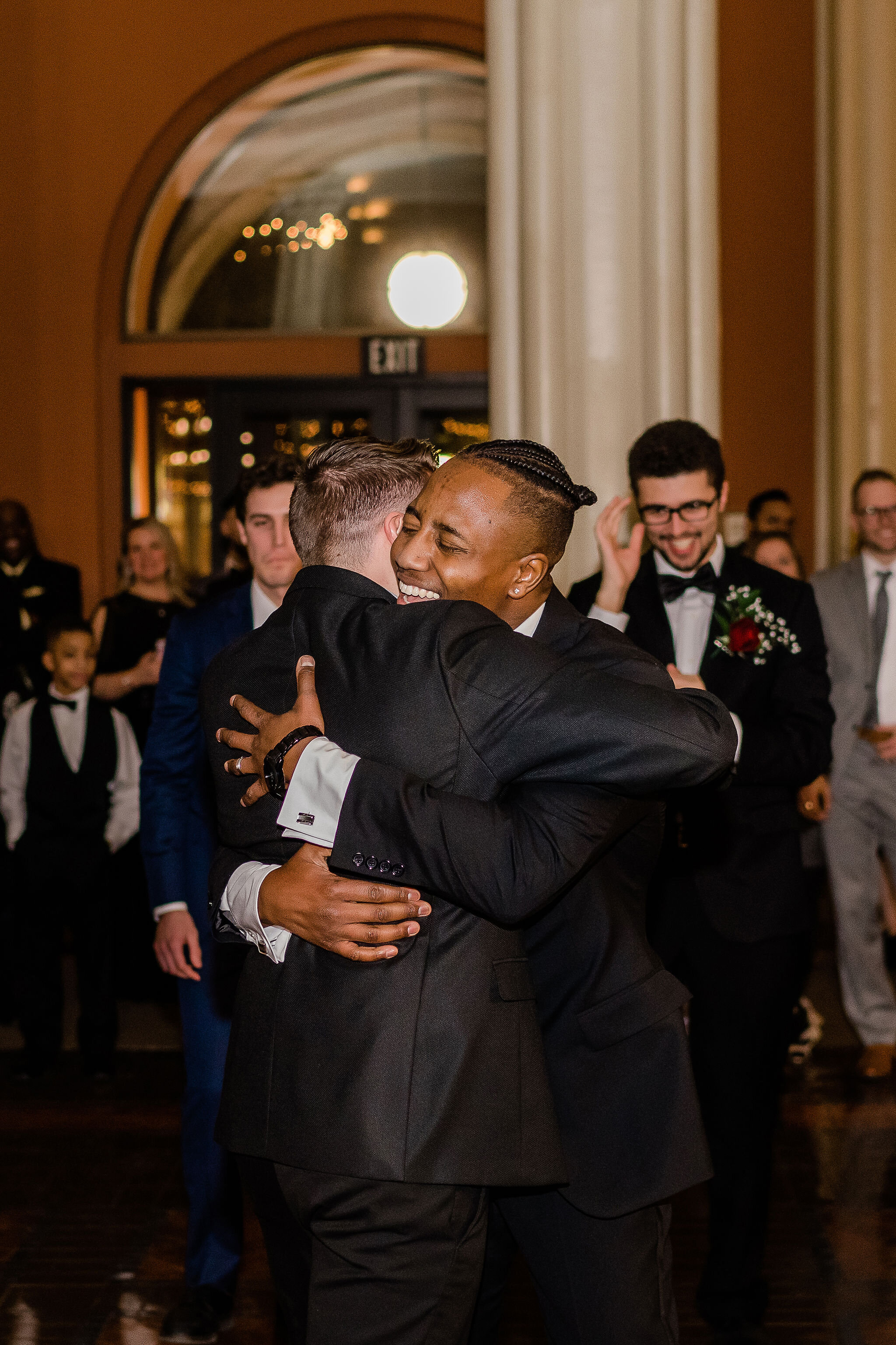 Groom hugging the wedding guest who caught the garter