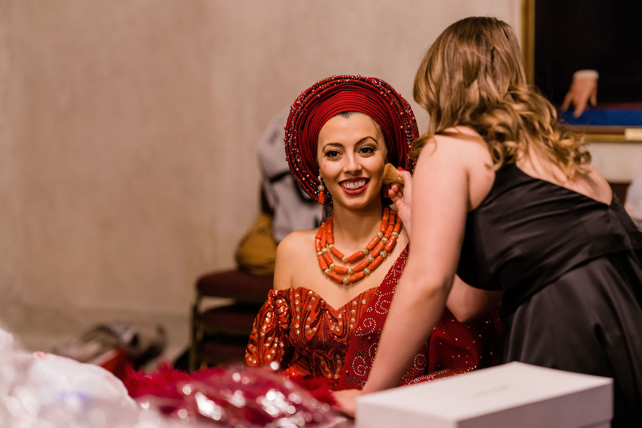 Bride in aso-ebi getting her makeup touched up