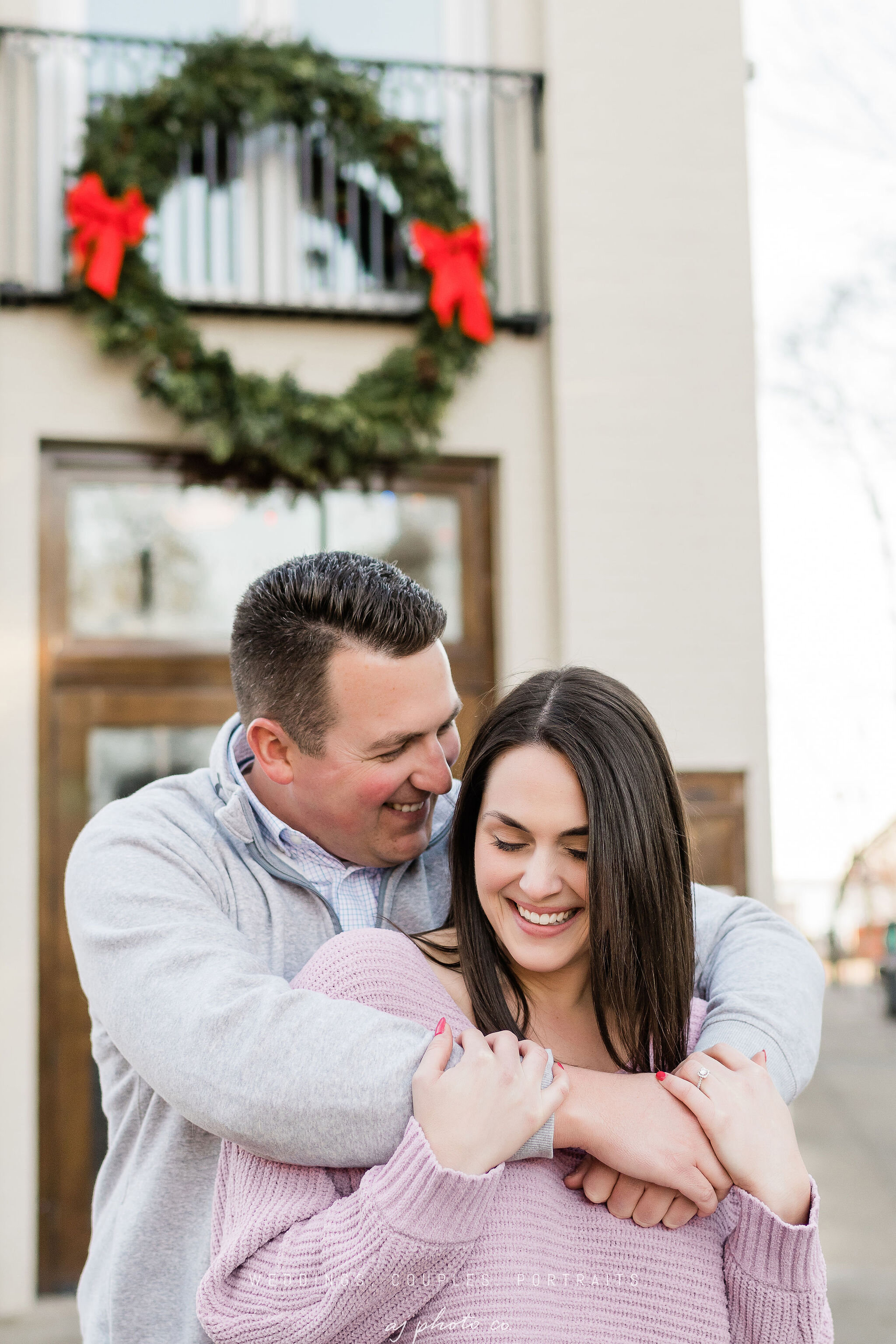 Engaged couple snuggling in front of Lucille in Madison, WI