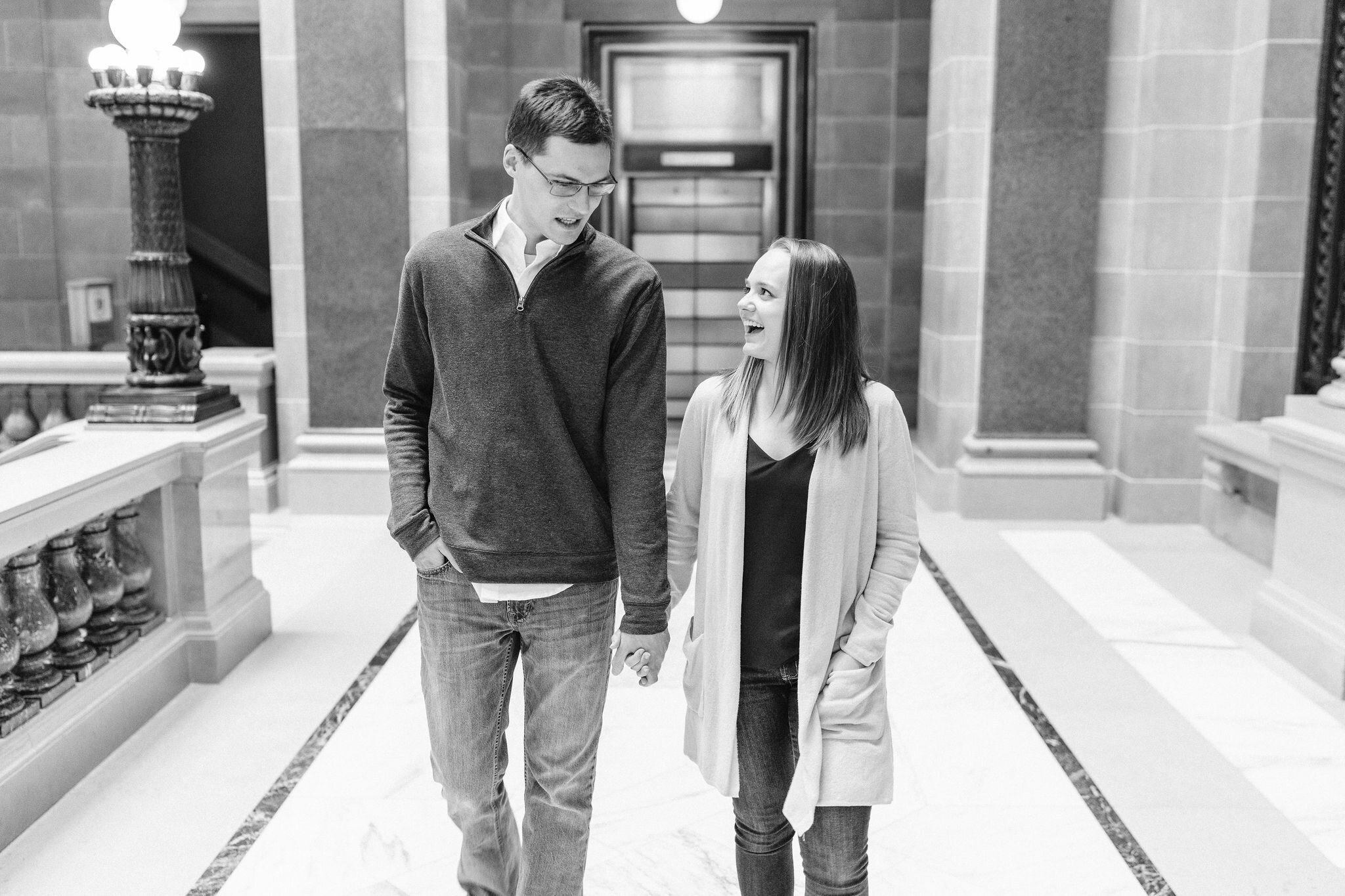 Engaged couple walking inside Wisconsin State Capitol in Madison, WI