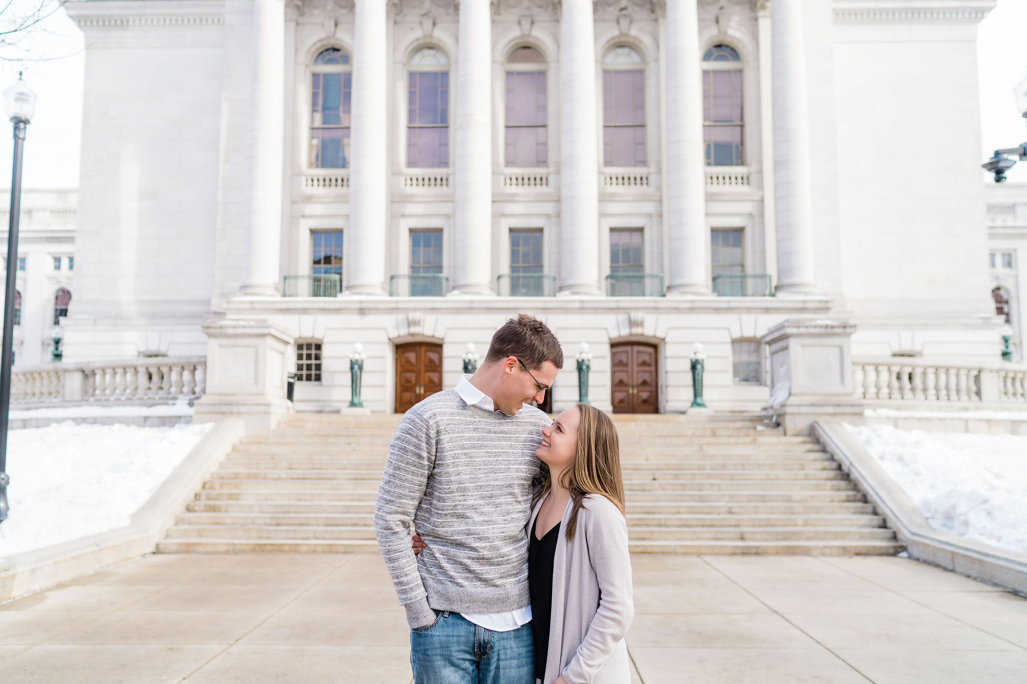 Engaged couple in front of Wisconsin State Capitol in Madison, WI