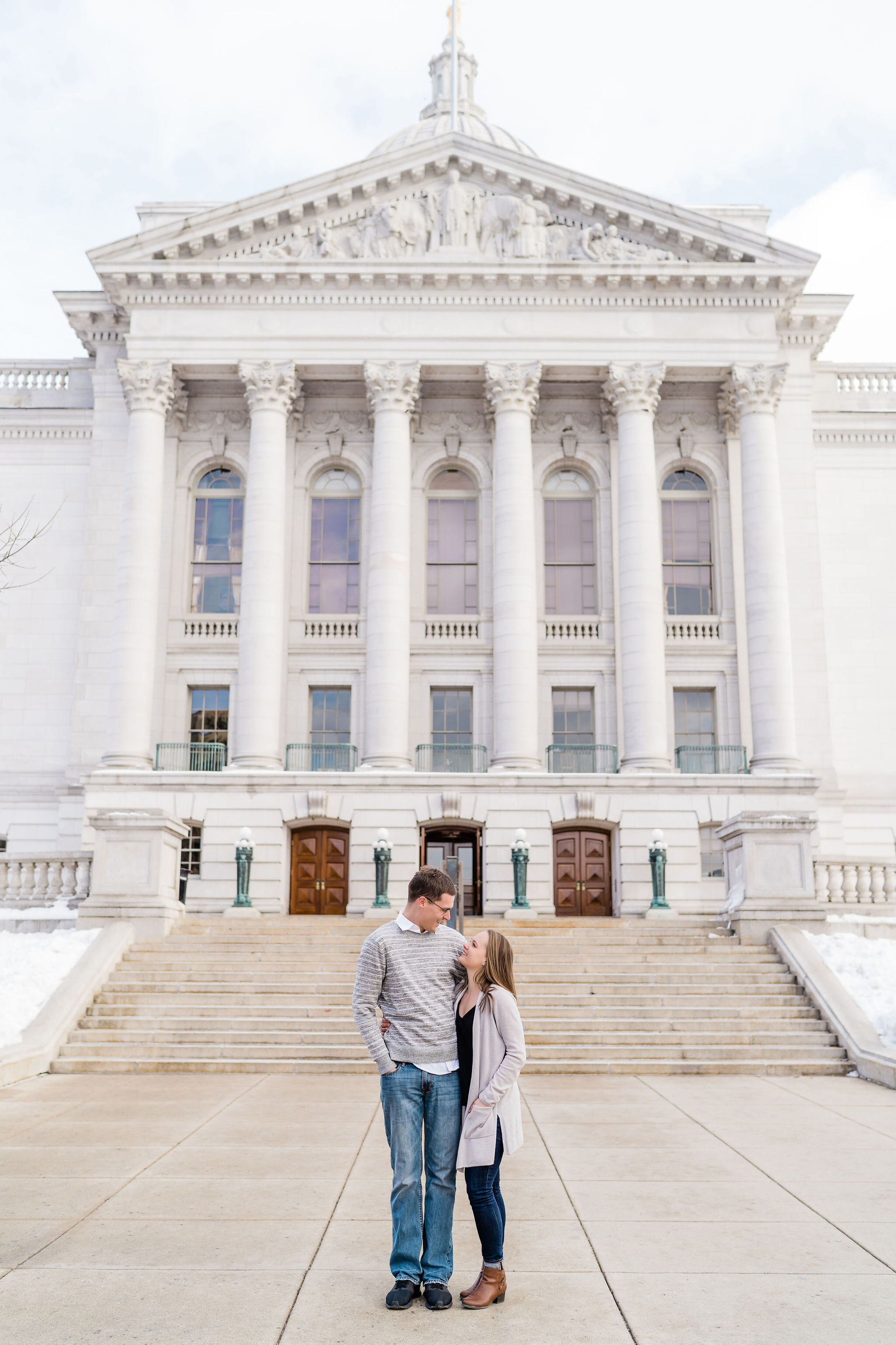 Engaged couple in front of Wisconsin State Capitol in Madison, WI