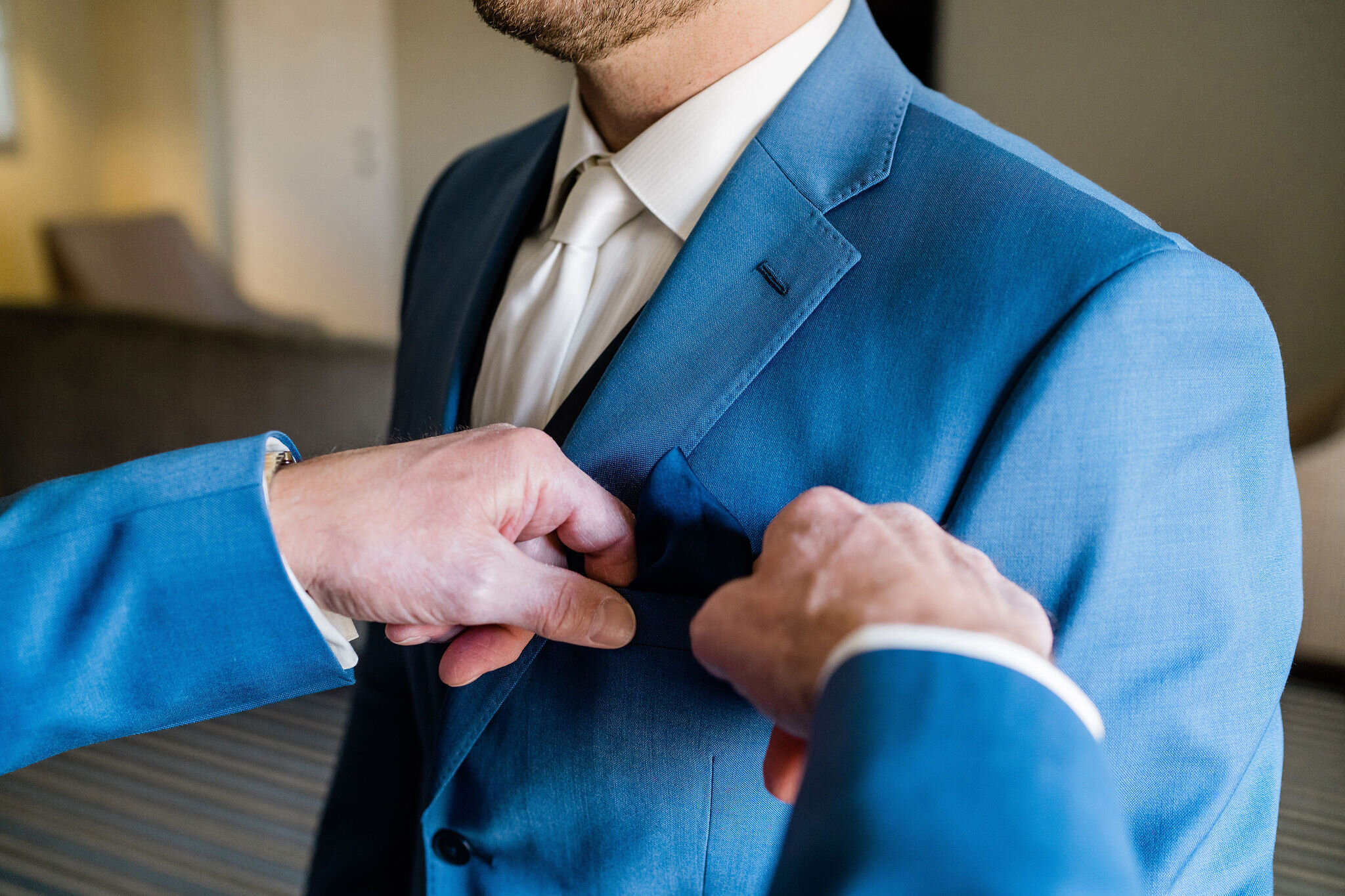 Groom putting his pocket square in