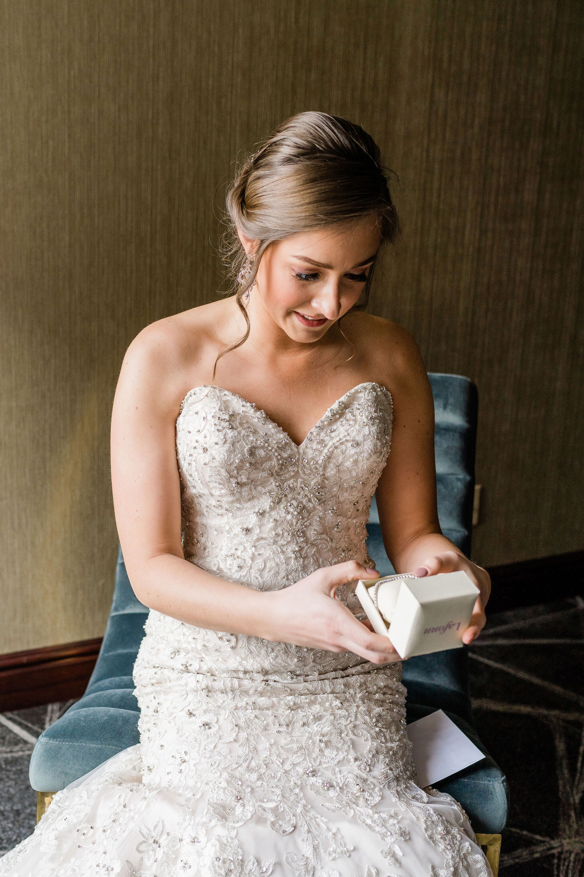 Bride opening up a gift from the groom