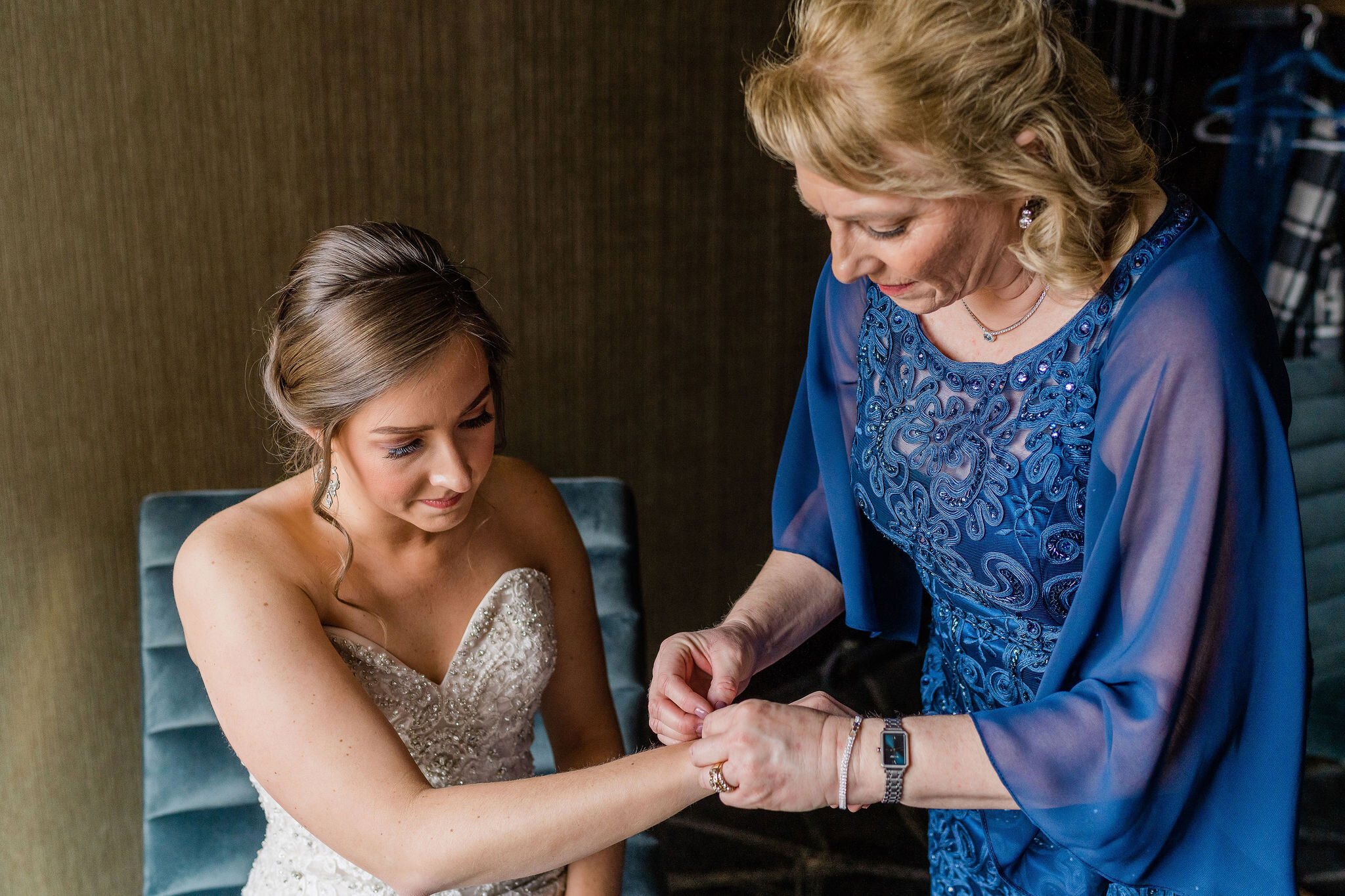 Mother of the bride putting the bracelet on the bride