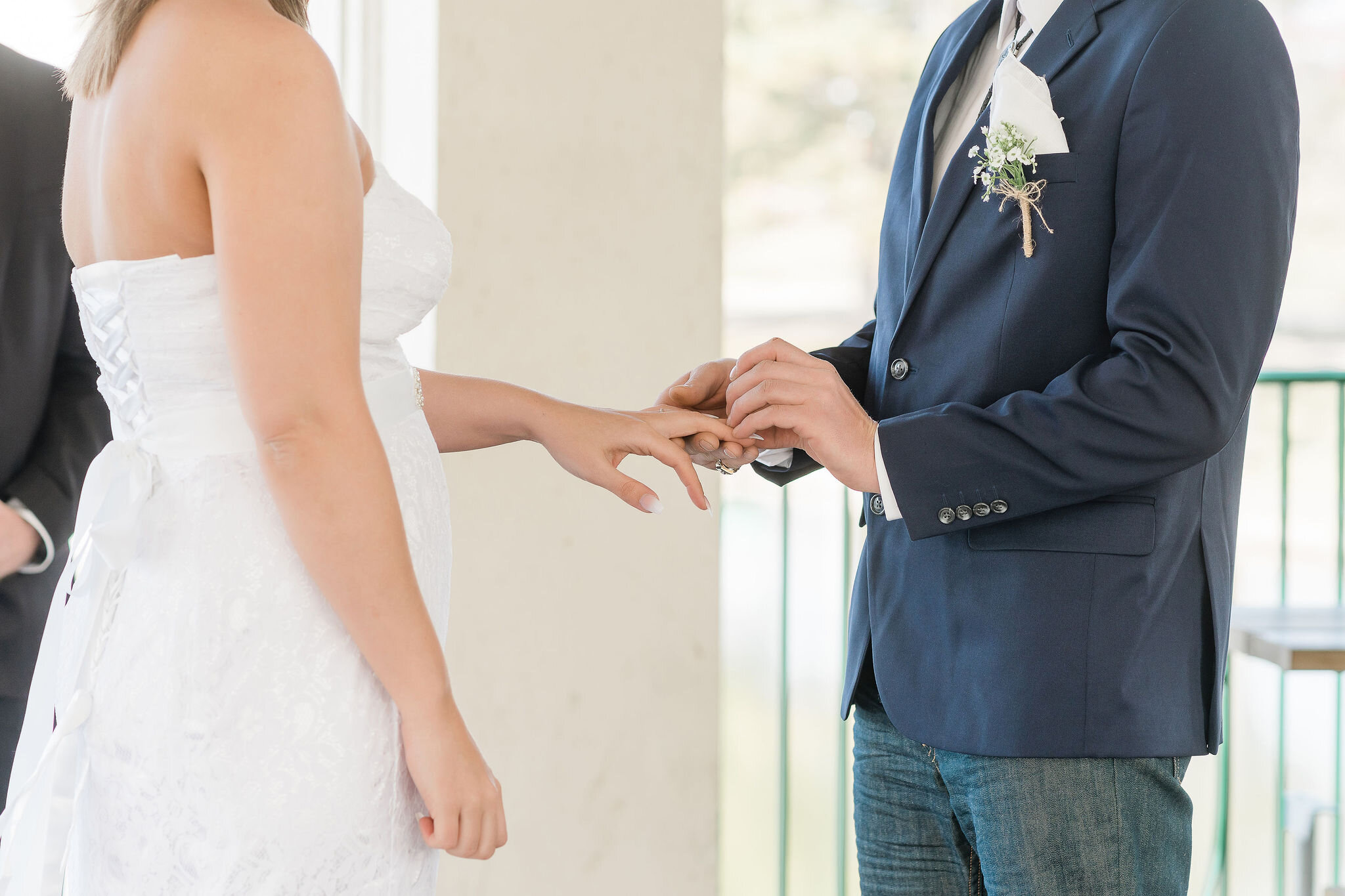 Groom putting ring on bride's finger