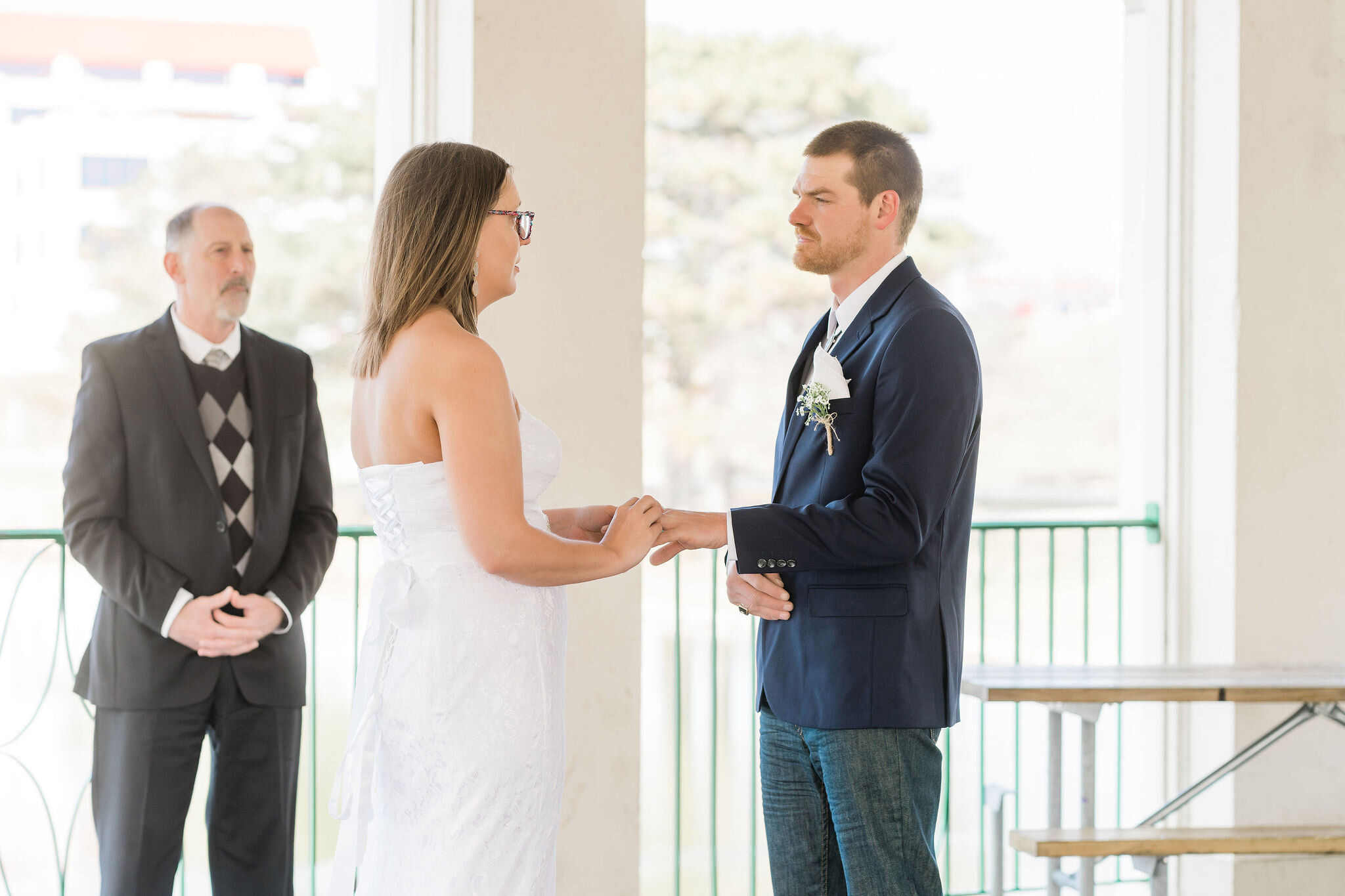 Bride putting ring on groom's finger