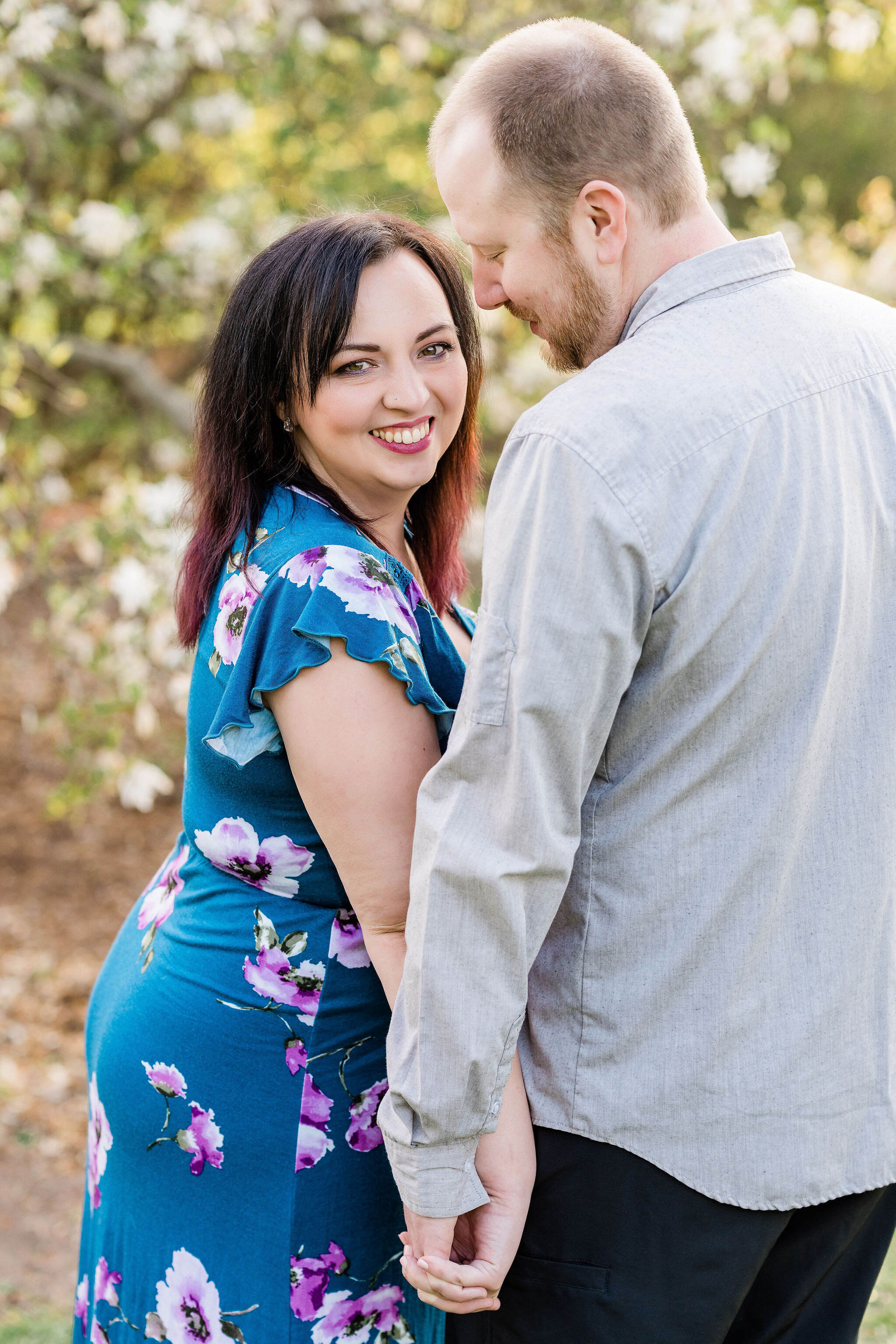 Woman holding hands with her fiancé and look at the camera