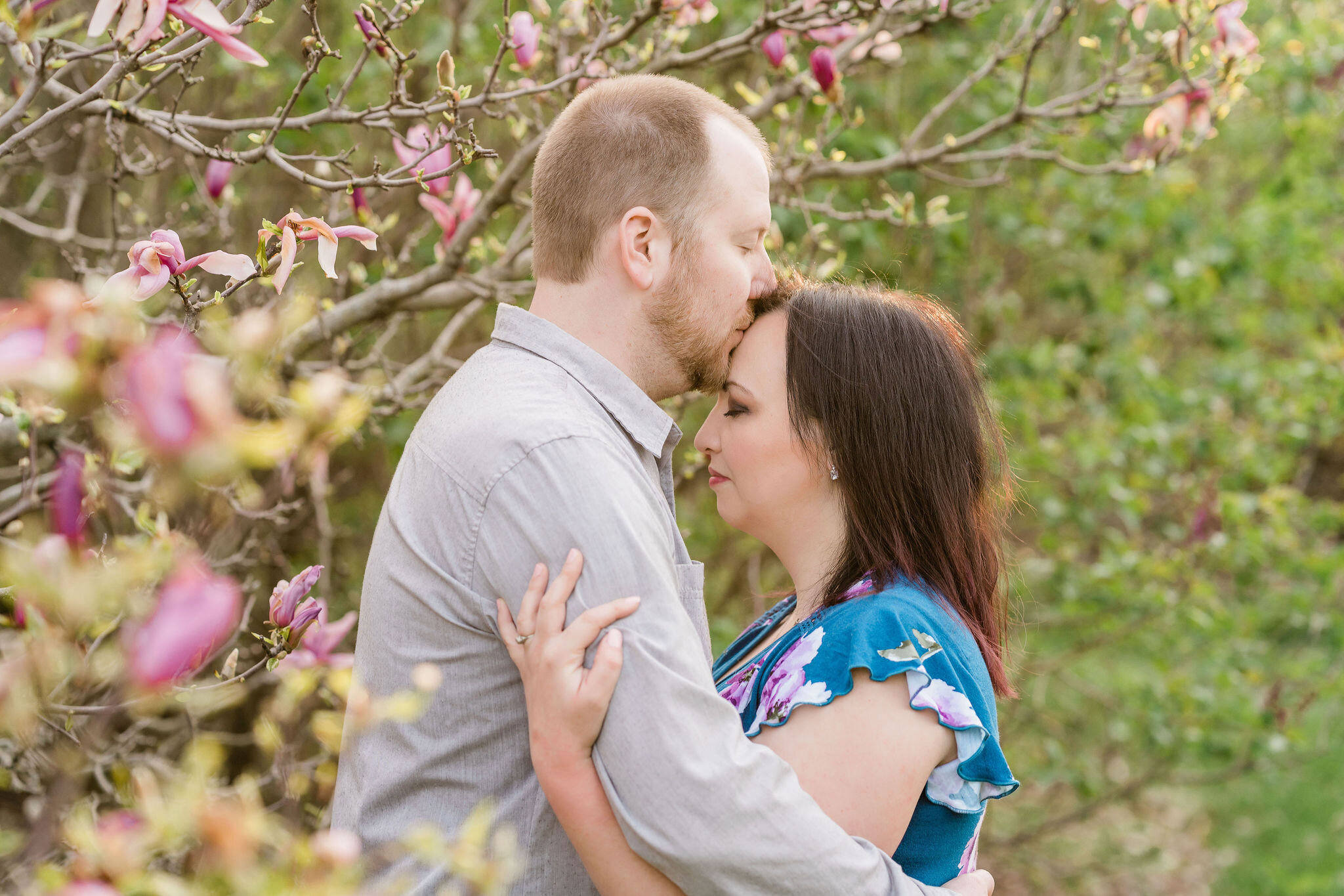Man kissing his fiancé's forehead