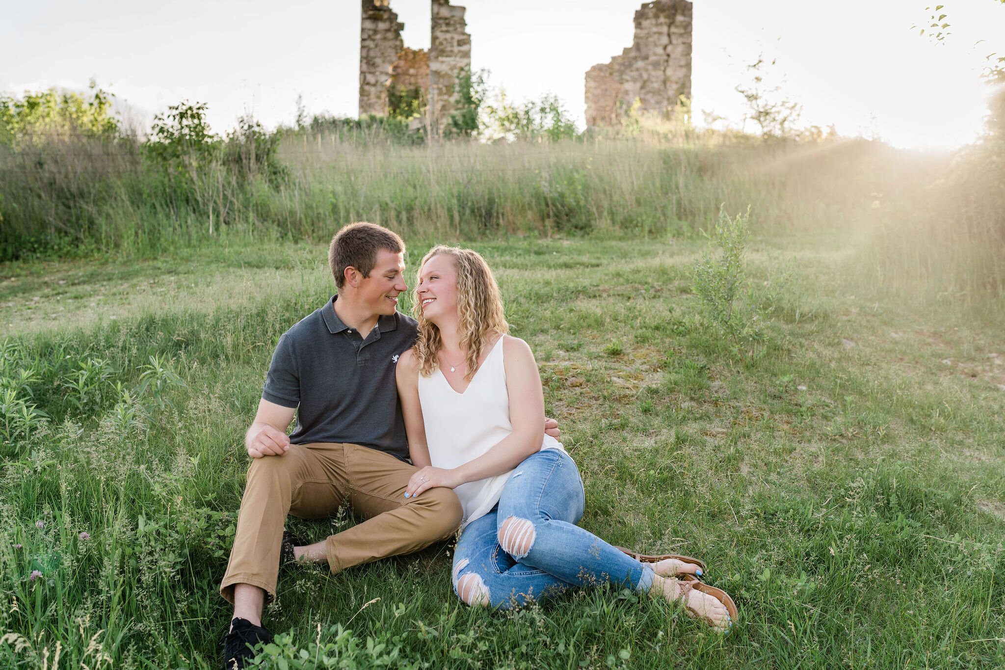 Engaged couple sitting on the grass